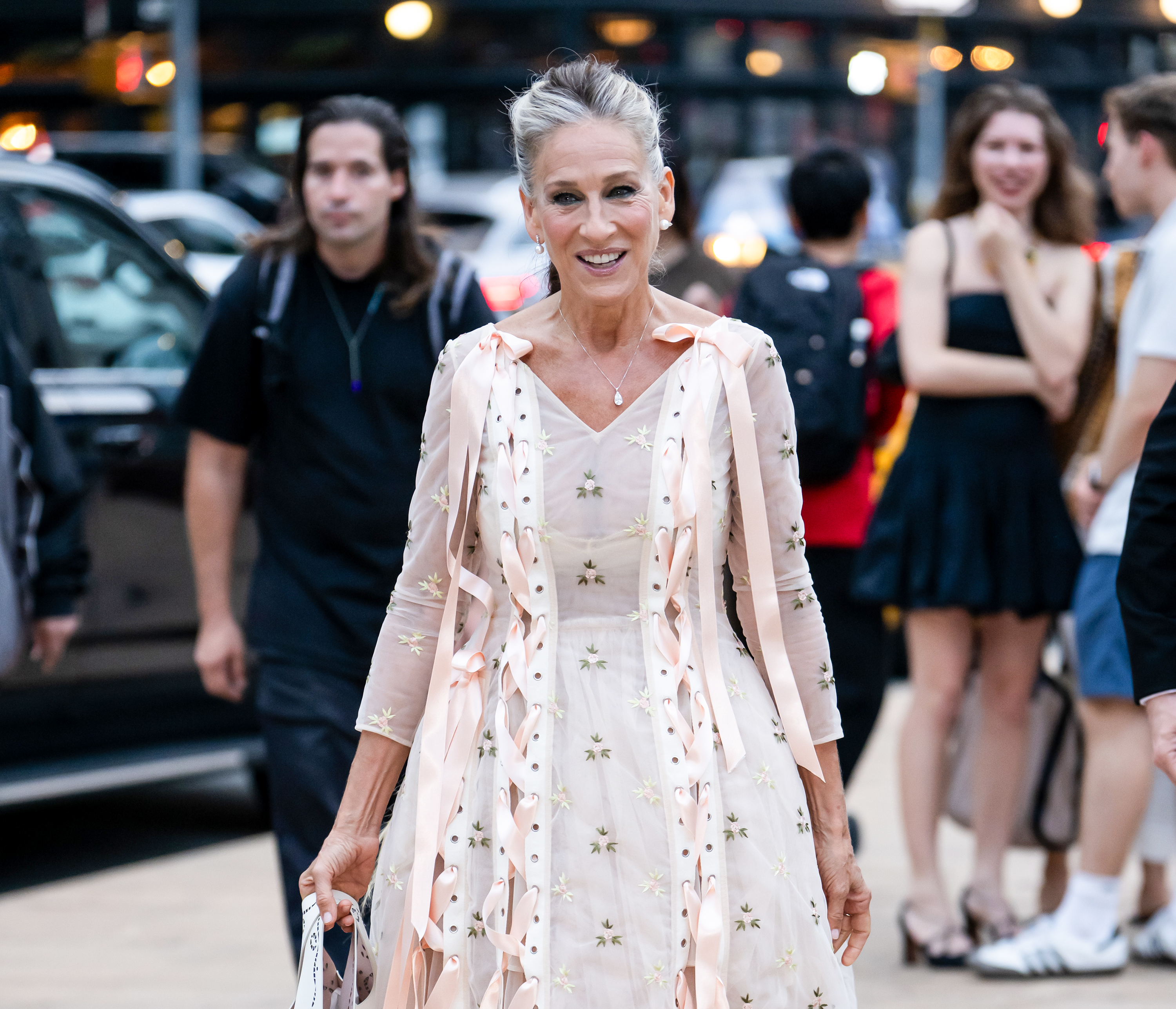 Smiling for photographers on October 1, 2026, Parker shows off her pale pink embroidered dress and understated jewelry. Her swept-back hairstyle leaves her natural-looking gray strands visible. | Source: Getty Images