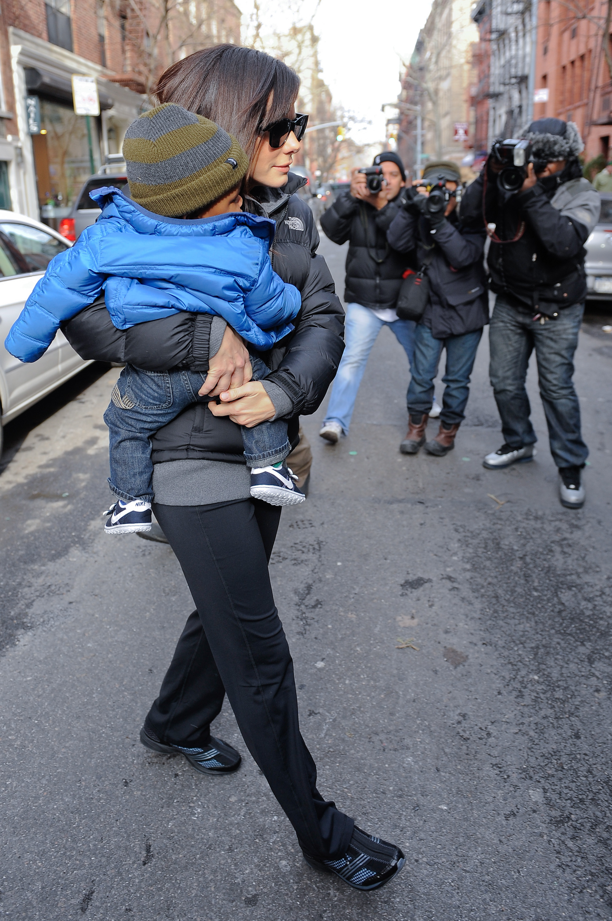 Sandra Bullock kept her young son Louis Bardo Bullock close as photographers followed them during a rare public outing, giving a glimpse of the intense media attention surrounding her family at the time. | Source: Getty Images