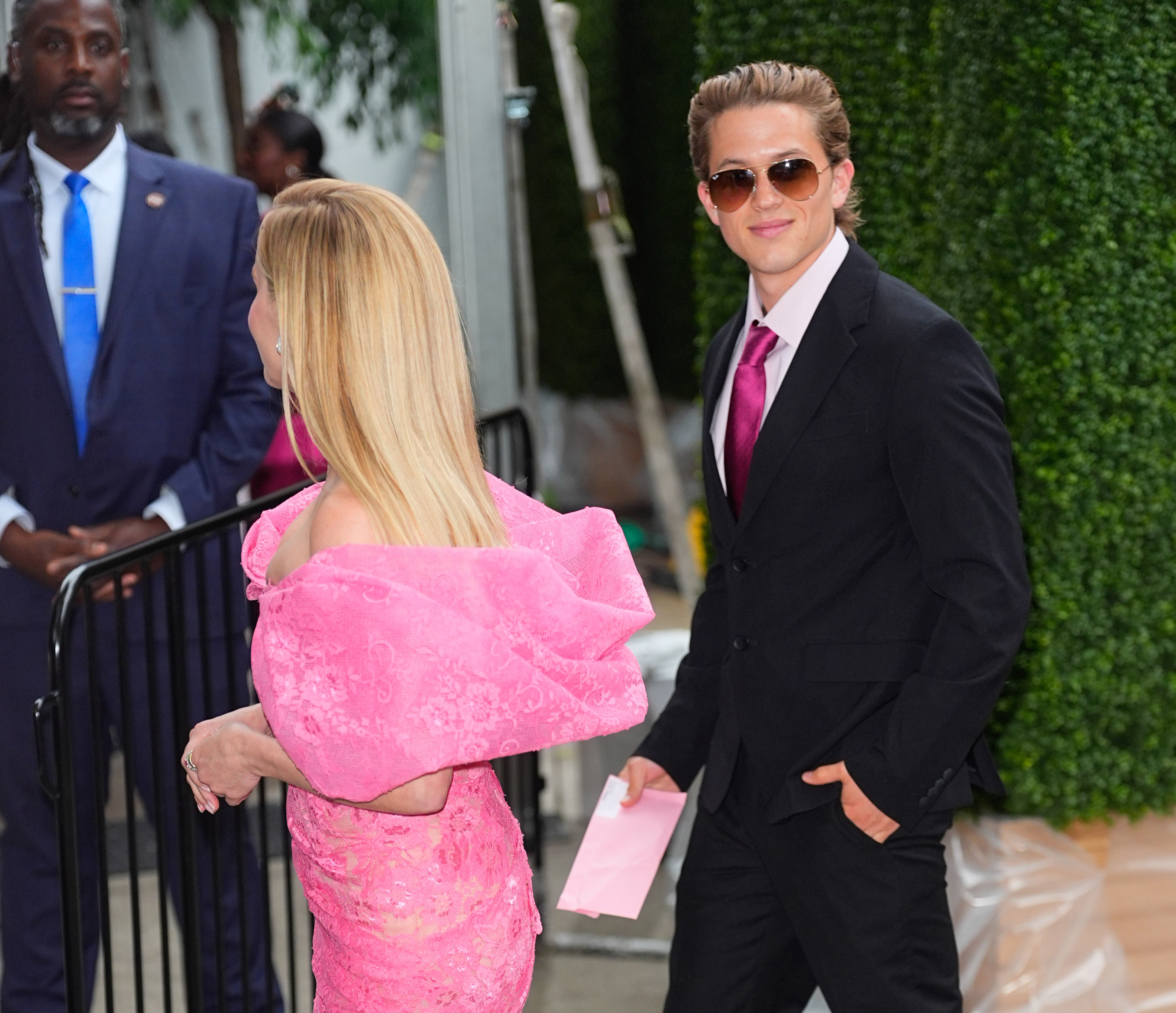 Reese Witherspoon and Deacon Phillippe arrive at the "Elle" premiere in New York City, with her bright pink dress standing out as he smiles in sunglasses and a black suit. | Source: Getty Images