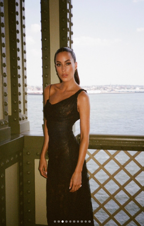 De Ramon gave a closer look at the black lace dress she wore to Taylor Swift and Travis Kelce's wedding, with its fitted silhouette and asymmetrical neckline visible in a waterfront portrait. Her hair was pulled into a sleek ponytail, completing the look for the ceremony. | Source: Instagram/lauriezanoletti