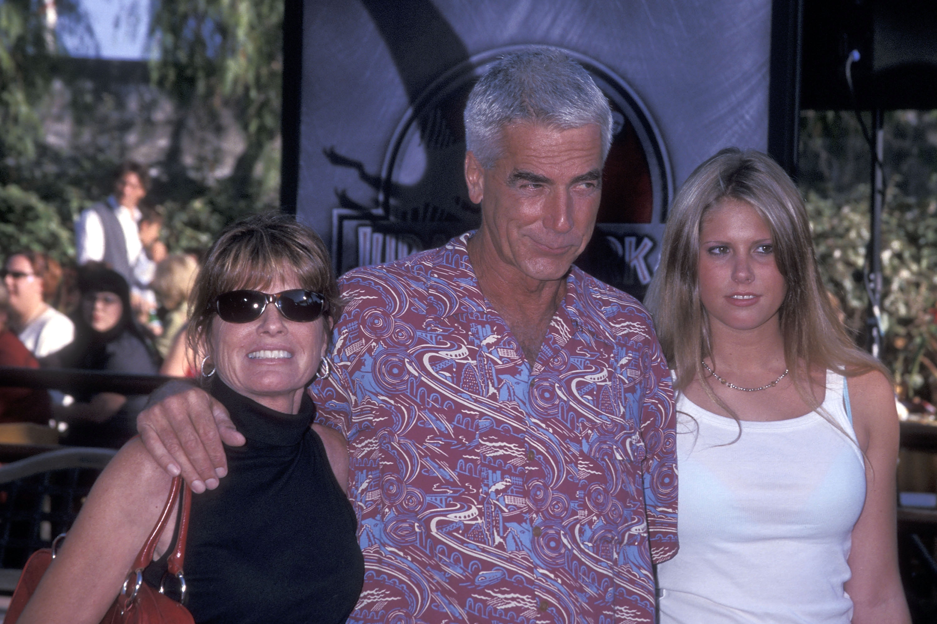 The renowned actor and his actress wife brought their blonde teenage daughter along for the fun at the "Jurassic Park III" premiere held at the Universal Amphitheatre on July 16, 2001, in Universal City, California. Embracing relaxed summer style, the actor wore a colorful patterned short-sleeve button-down shirt with an arm wrapped around his wife, who looked effortlessly cool in a black sleeveless top and dark sunglasses, while their daughter stood close beside them in a classic white tank top and delicate necklace. | Source: Getty Images