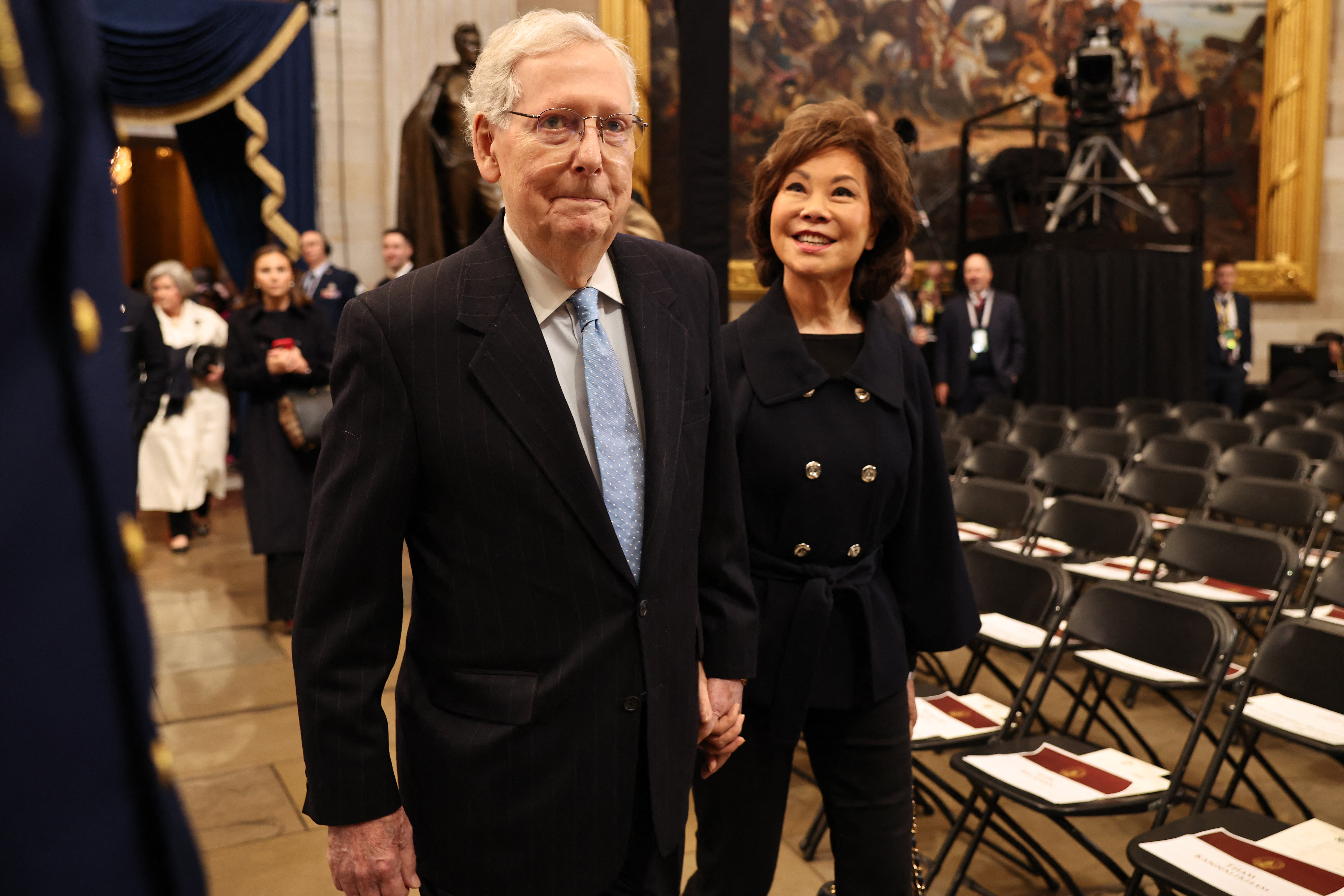 Mitch McConnell walks hand in hand with his wife, Elaine Chao, as the couple makes their way through a formal gathering. | Source: Getty Images