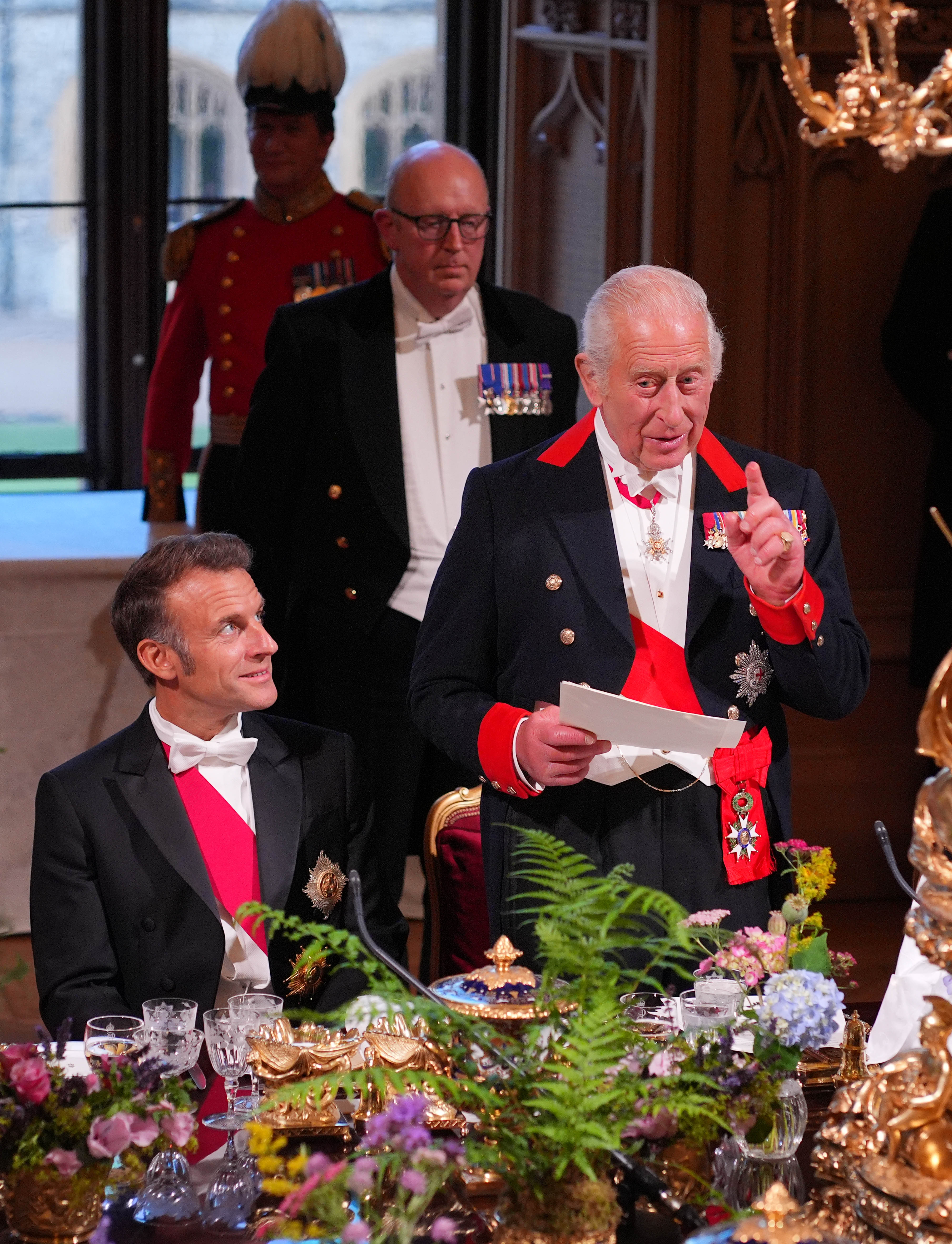 Emmanuel Macron looks on as King Charles III delivers his speech during the banquet held in west London in honor of the French President.