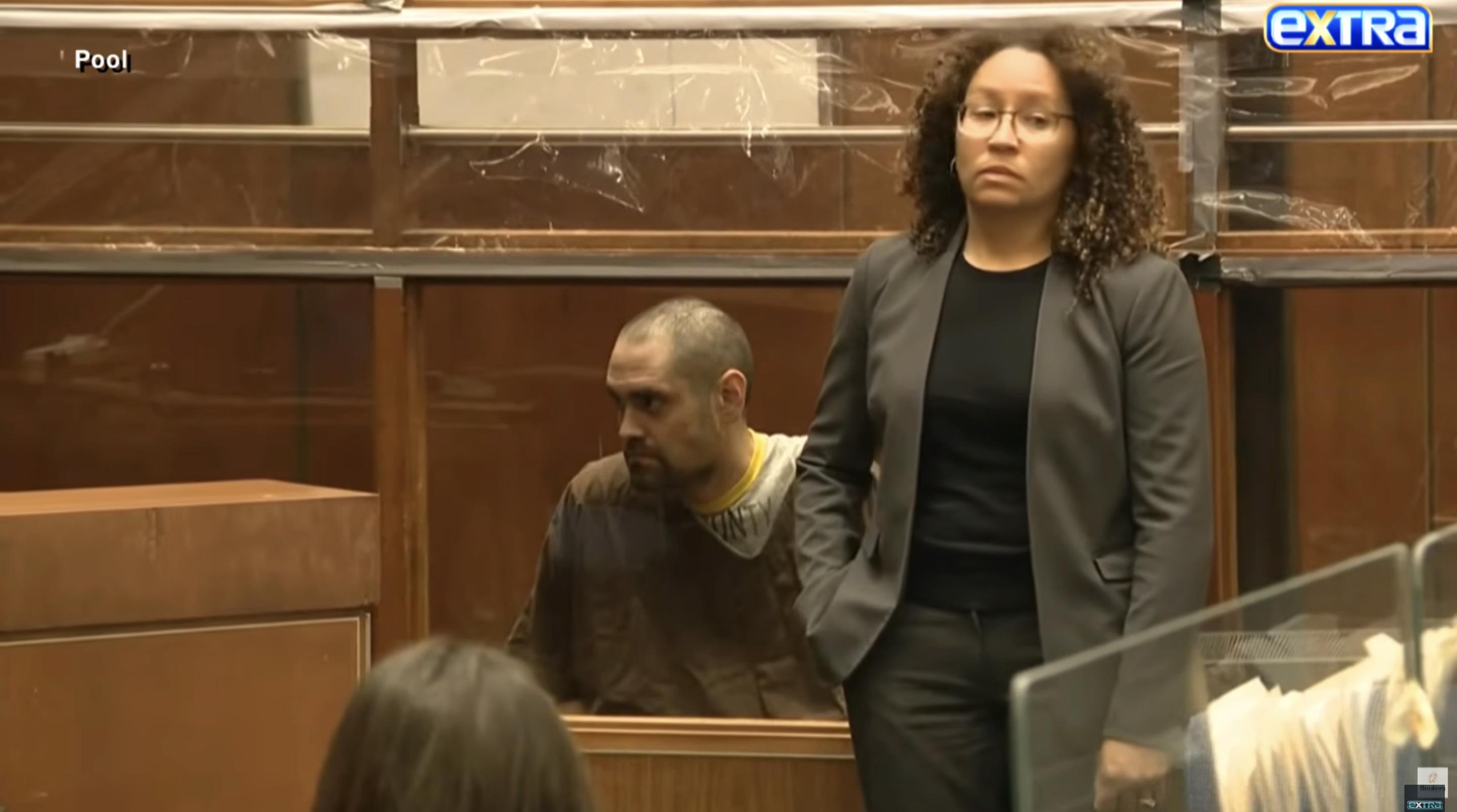 A wider courtroom view shows Nick Reiner seated behind a partition beside his attorney during the arraignment | Source: YouTube/ExtraTV