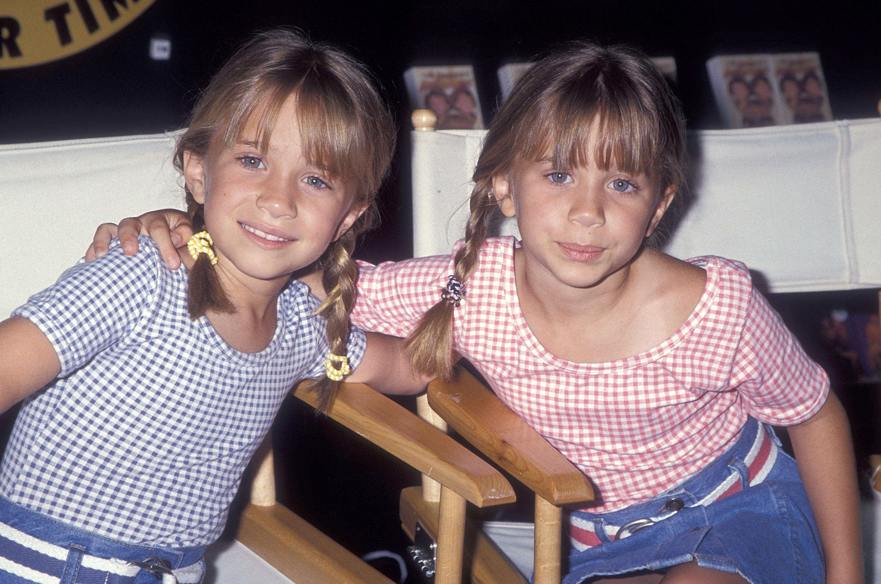 Noticeable lengthening of their facial contours marked the 8-year-old duo on July 25, 1994, appearing sunny and energetic in complementary red and blue gingham button-ups with denim skirts, their blonde hair parted into neat pigtail braids fastened with bright accessories.