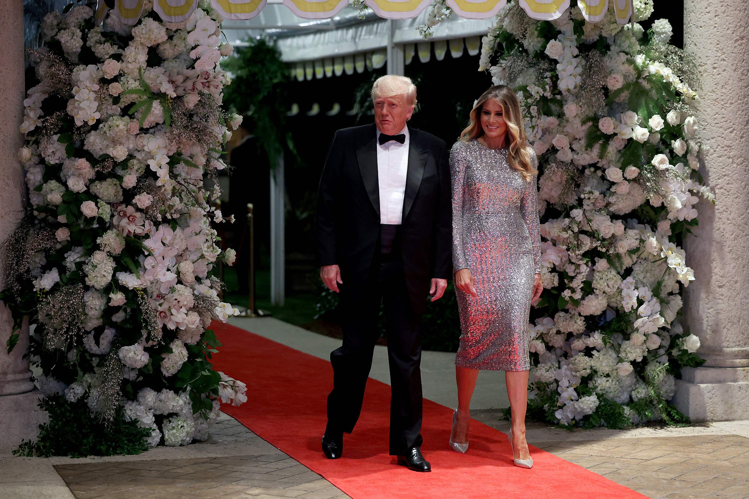 Melania Trump arrives for a New Year's Eve celebration at Mar-a-Lago in Palm Beach, Florida, on December 31, 2022, wearing a shimmering silver sequined midi dress accompanied by reflective silver pointed-toe stiletto pumps that elongate her evening silhouette with needle-thin heels.