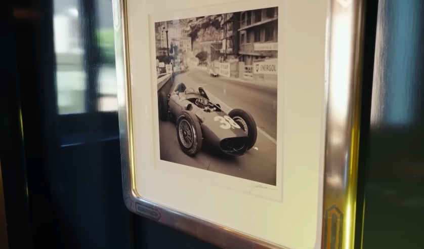 The racing photographs give the media room a more masculine edge. They also add to the space's collected, clubby atmosphere. | Source: YouTube/Architectural Digest