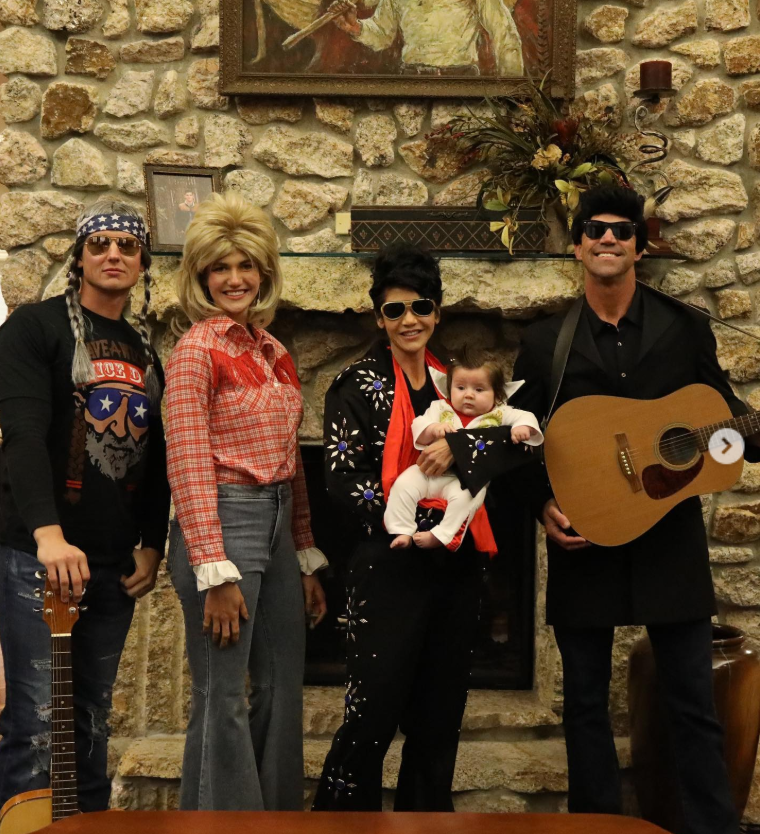 A living-room stage of country legends—Bryon Noem channels Johnny Cash with a guitar in hand, flanked by playful takes on Dolly, Willie, and Elvis, turning the fireplace into a front-row seat. | Source: Instagram/sdbryonnoem