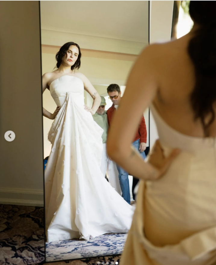 Tallulah Willis checks the fit of her custom Balenciaga gown in the mirror, offering a striking view of the strapless front and flowing train while the dress’s open back remains visible in the foreground. | Source: Instagram/vogueweddings