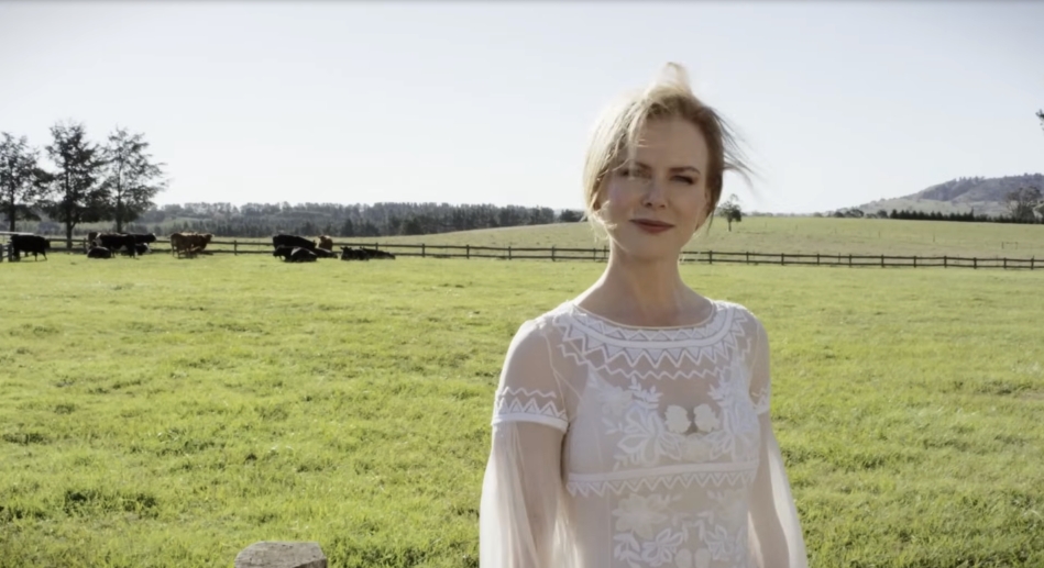With cattle grazing behind her and open hills beyond, this quiet moment reflects the natural rhythm and openness of rural life on the expansive property. From a video dated July 20, 2015. | Source: YouTube/Vogue