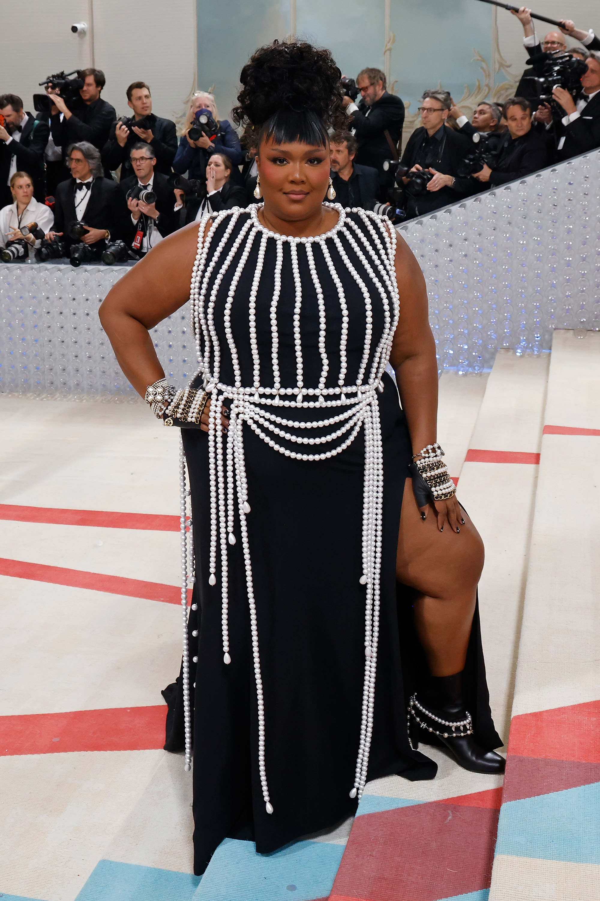 At the Met Gala, Lizzo strikes a commanding pose, her presence radiating confidence amid one of fashion’s most prestigious stages. Adorned in intricate, pearl-draped detailing, the look cements her evolution into a true style icon — bold, elevated, and unforgettable.