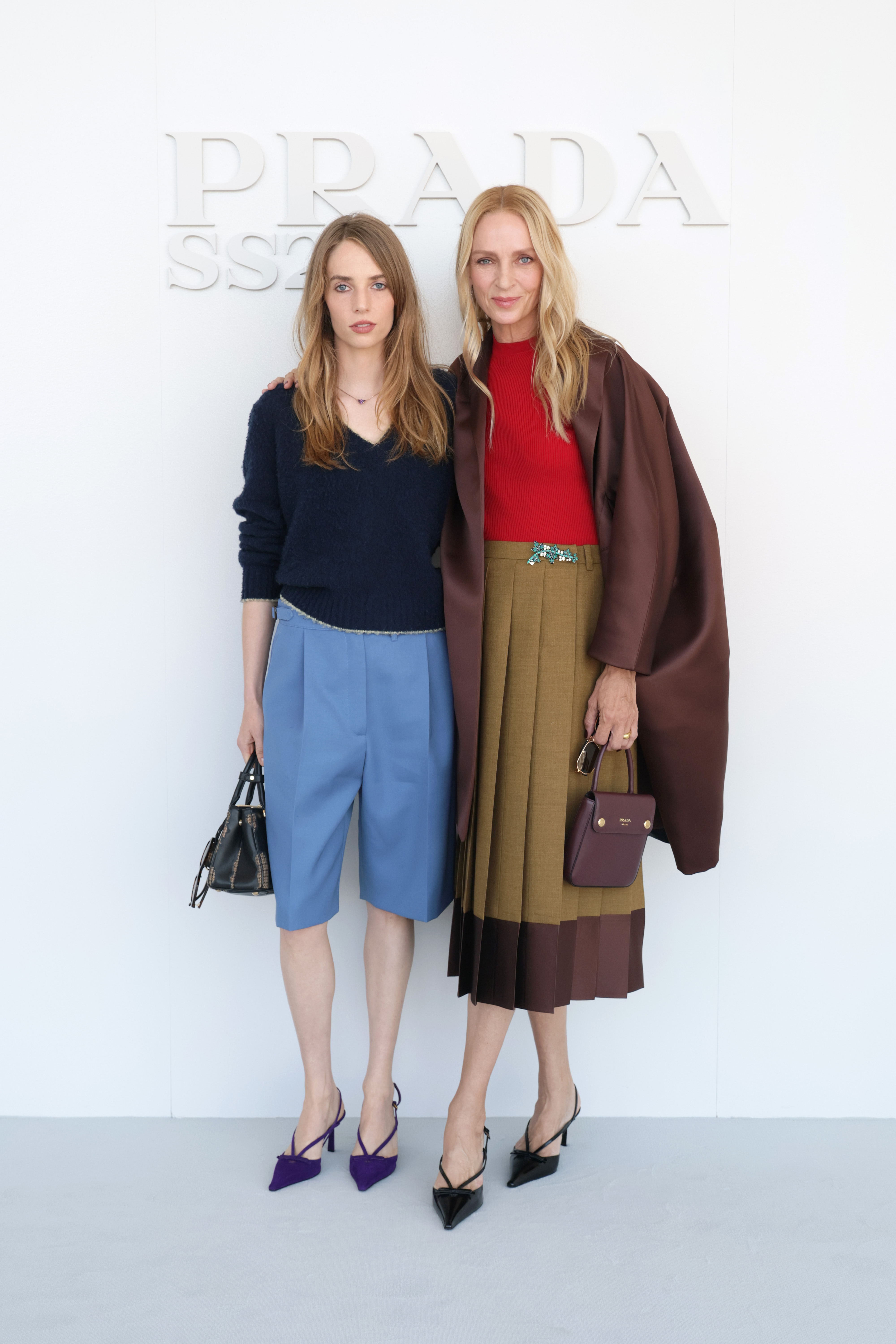 The mother-daughter pair pose together before the show, giving a complete view of Hawke's powder-blue shorts and purple pumps alongside Thurman's layered brown skirt and coat. | Source: Getty Images