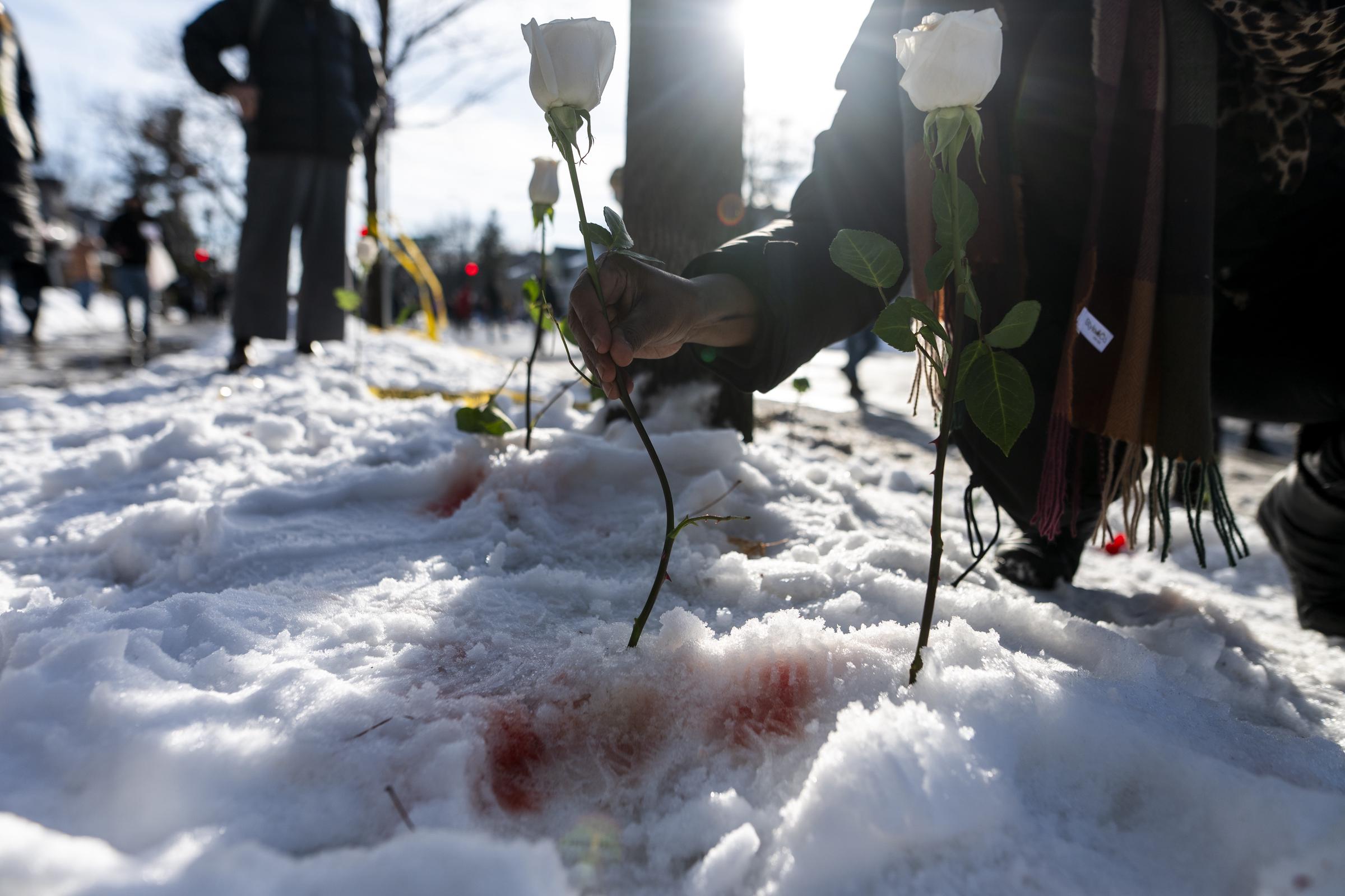 A person places a white rose at the scene where Renee Nicole Good was shot and killed by an ICE agent in Minneapolis on January 7, 2026. | Source: Getty Images