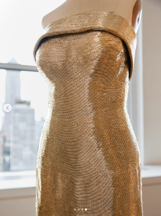 Oscar de la Renta's gold bugle-bead gown for Usha Vance is shown on a mannequin, highlighting its strapless silhouette, sculpted neckline and densely embellished column shape. | Source: Instagram/oscardelarenta