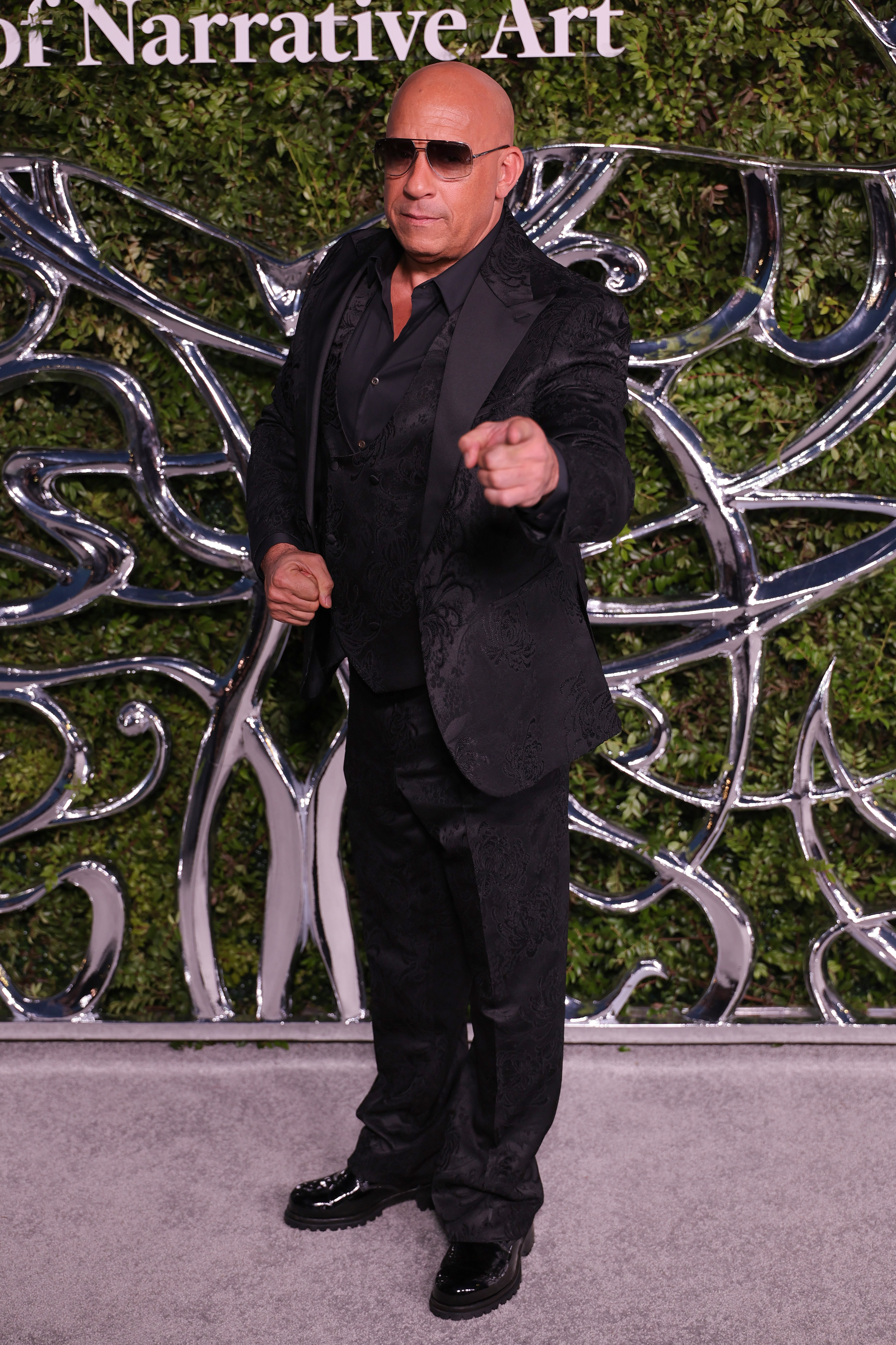 Vin Diesel pointed toward the camera while posing at the opening-night event. His playful gesture gave photographers something different from the night's more traditional poses. | Source: Getty Images