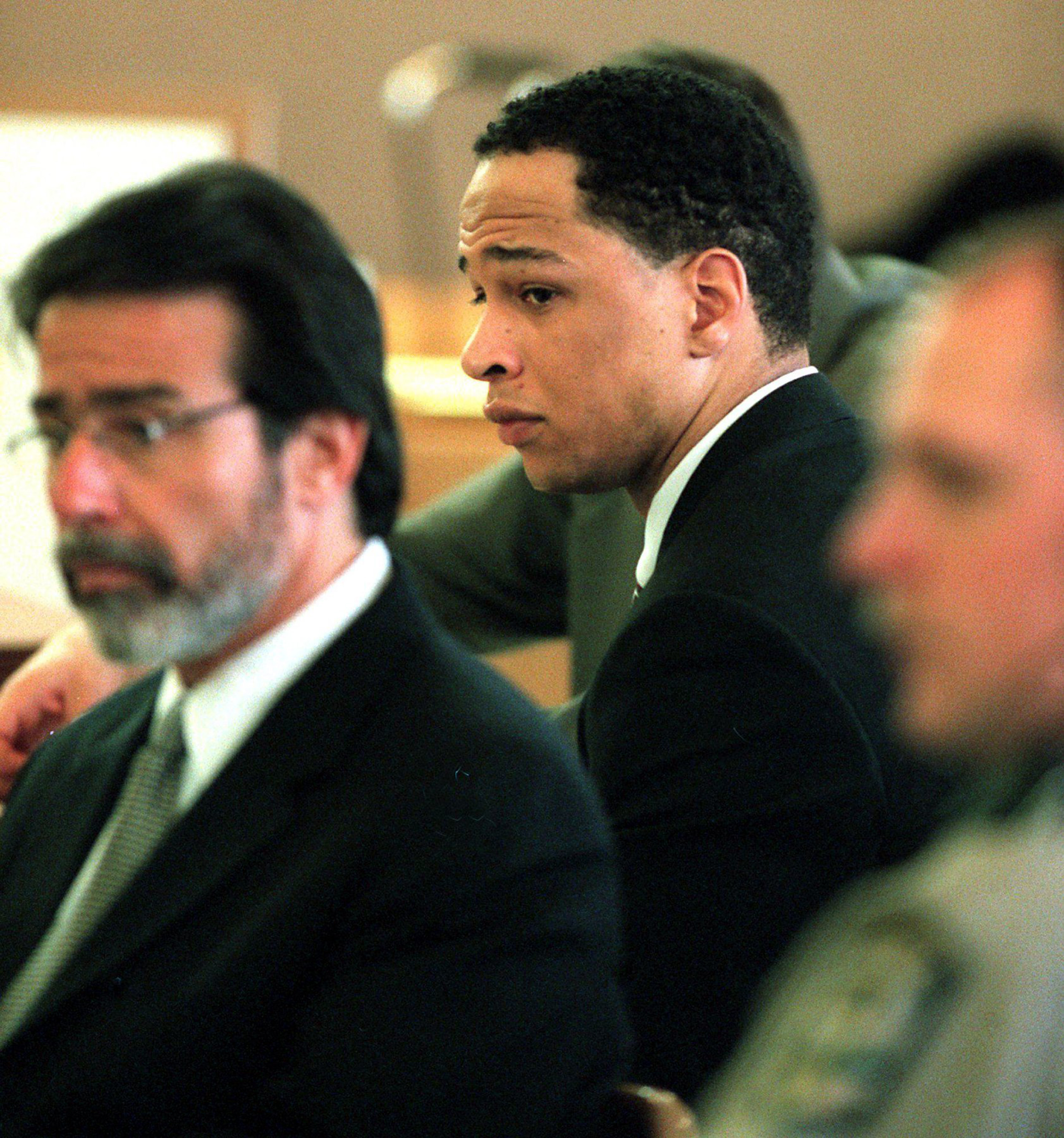 Rae Carruth sat beside defense attorney David Rudolf as prosecutors addressed the courtroom during his murder trial in Charlotte, North Carolina, on January 11, 2001. The former Carolina Panthers wide receiver faced charges stemming from the 1999 shooting of Cherica Adams, who was pregnant with his son at the time. Carruth was ultimately convicted of conspiracy to commit murder and later served nearly 19 years in prison.