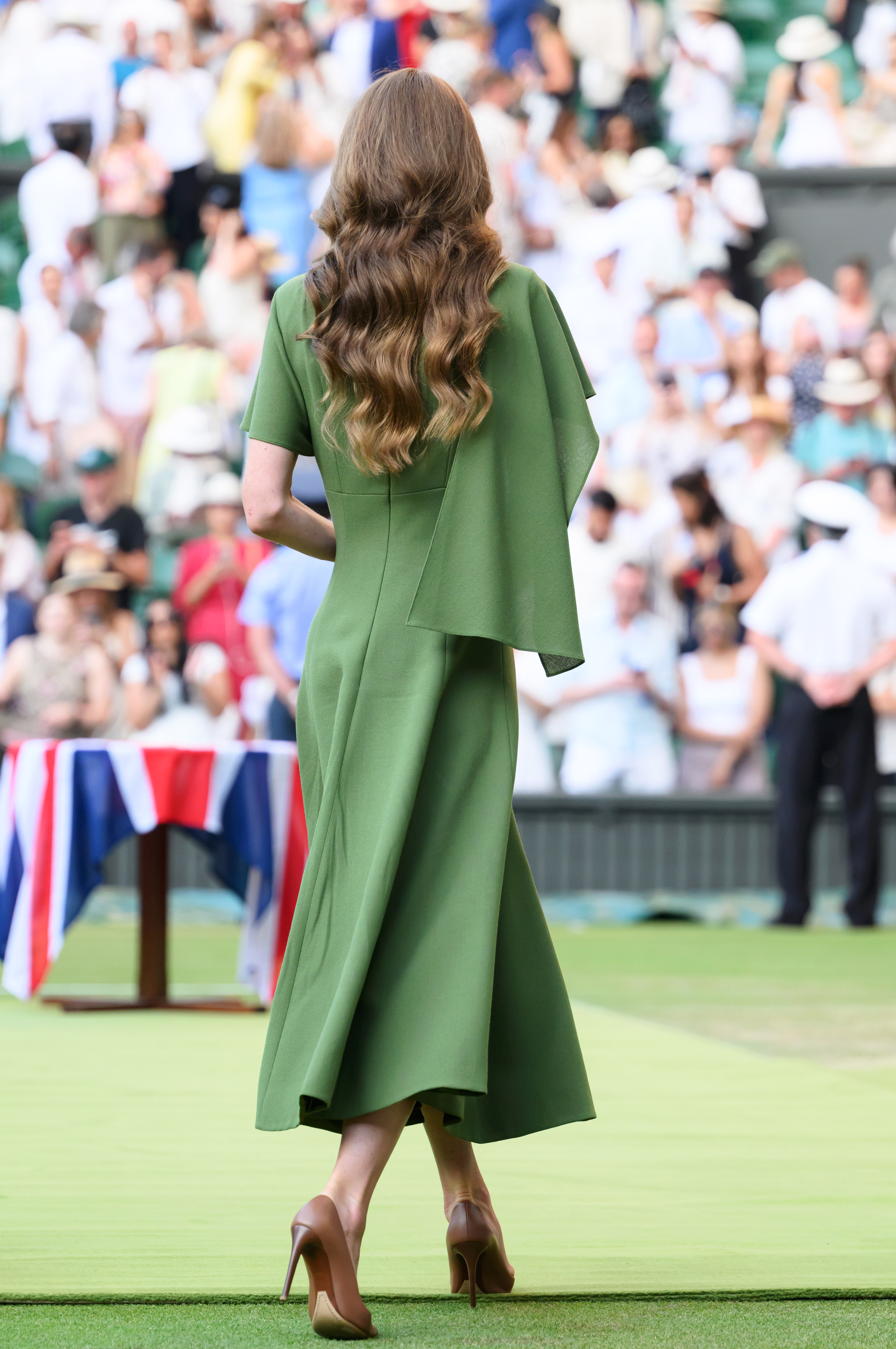 This rear view highlights the flowing silhouette of Catherine's custom Emilia Wickstead dress as she crossed Centre Court. The elegant design reflected the understated style she chose for the final day of the Championships. | Source: Getty Images