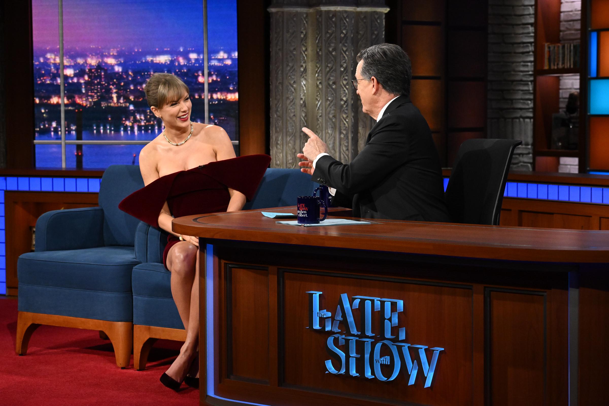 Taylor Swift shares a candid laugh with Stephen Colbert during a lighthearted exchange. Her confident, relaxed demeanor contrasted the viral buzz that her statement dress would go on to generate online after the broadcast.
