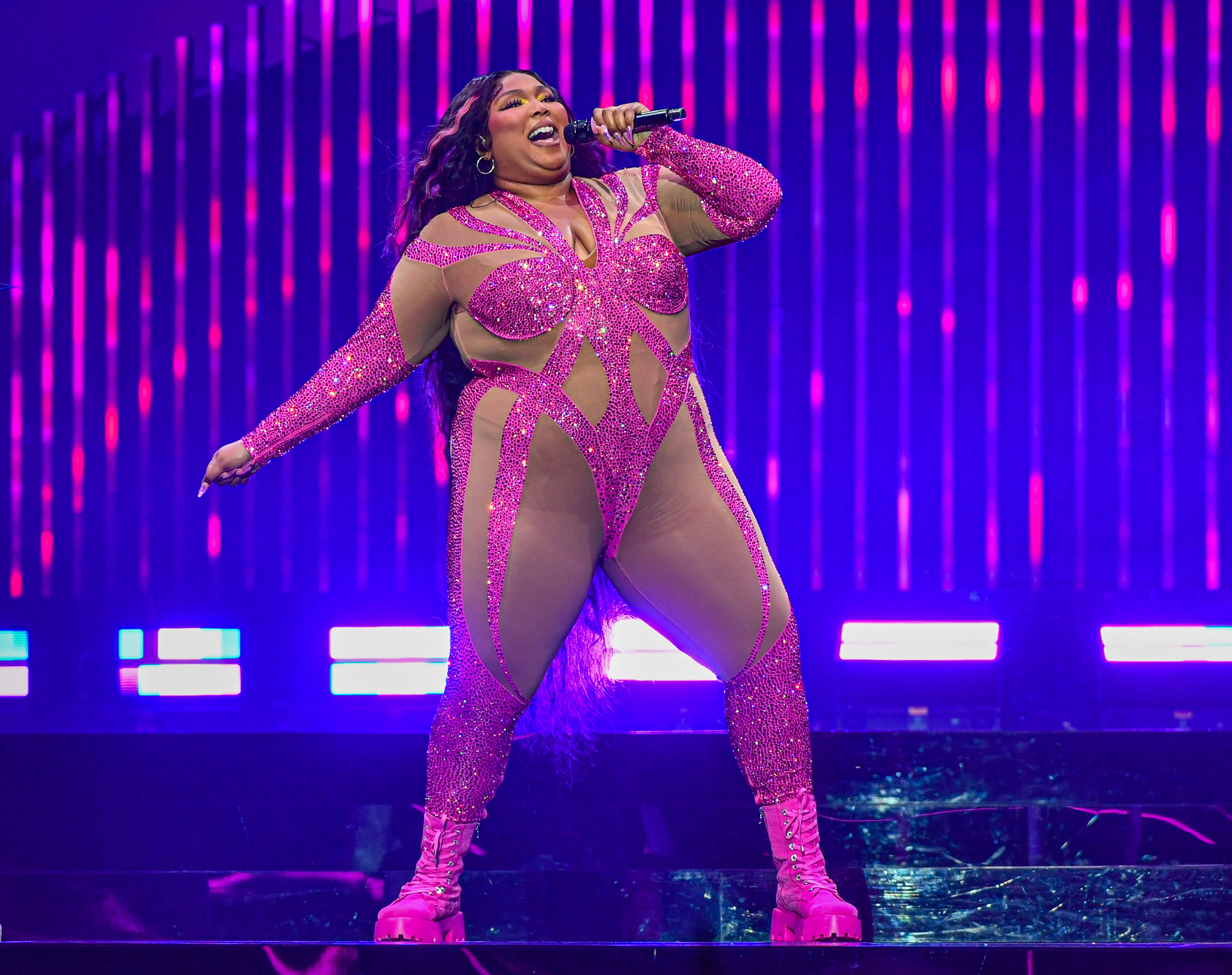 Onstage in Detroit in October, Lizzo performed in a sheer nude bodysuit with bold fuchsia sequin paneling that emphasized her full curves, thick thighs, and round midsection. The skin-tight look left little to the imagination, showcasing her pre-weight-loss physique in motion.