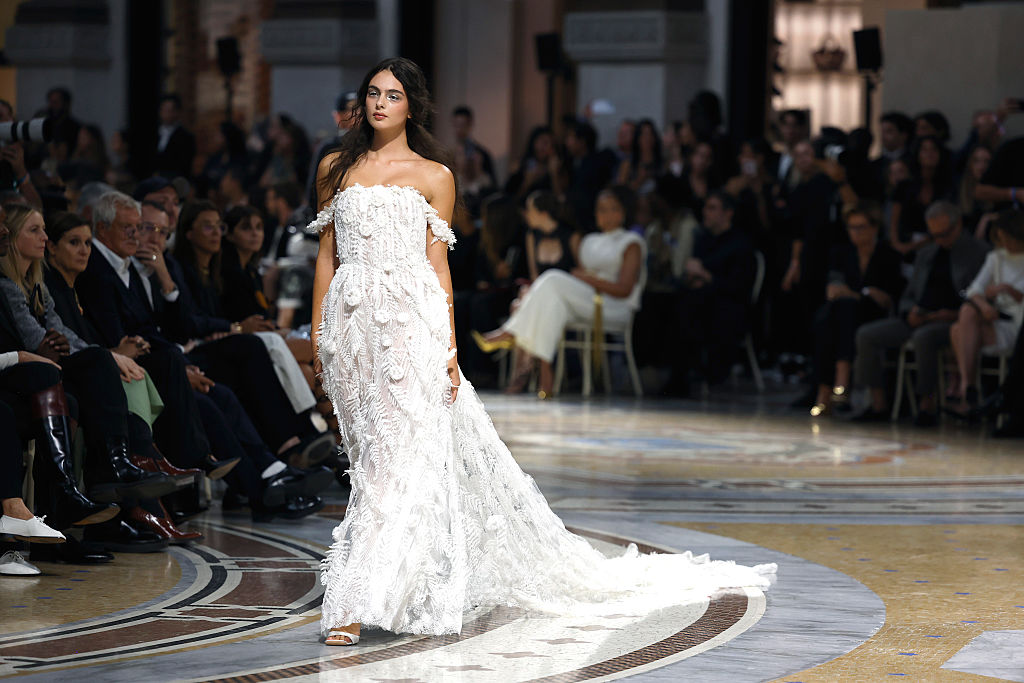 A wider perspective of the catwalk captured the drama of Deva Cassel's sweeping train gliding across the polished mosaic floors. Commandingly owning the spotlight, the rising star walked tall before seated fashion insiders, bringing the spectacular Italian showcase to life with quiet poise. | Source: Getty Images