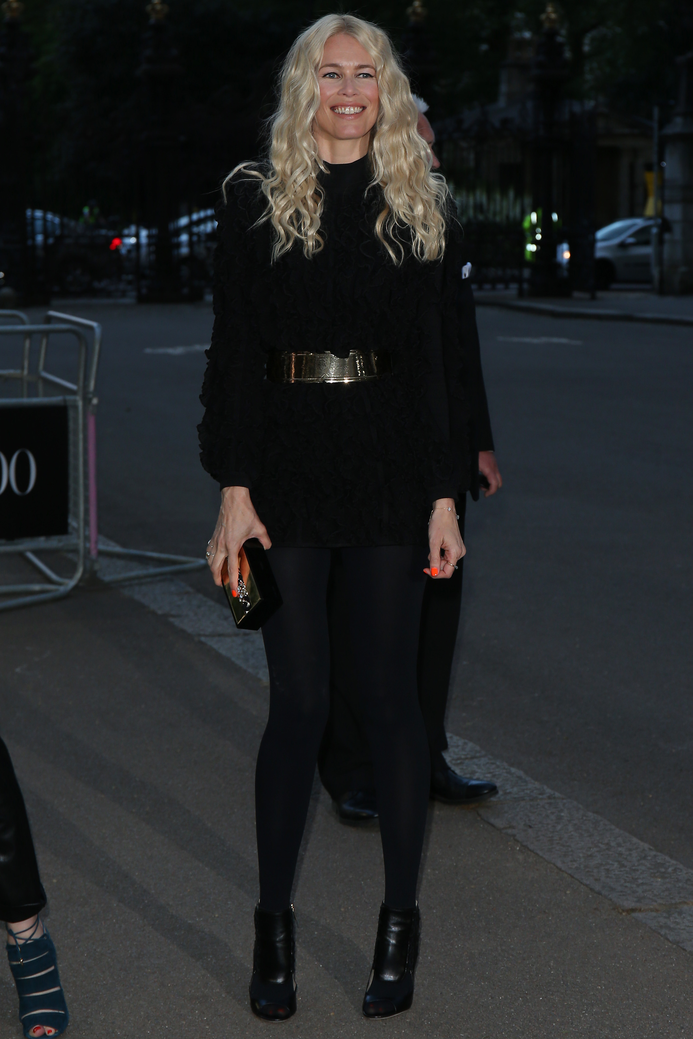 Claudia Schiffer stuns at the Vogue 100 Gala Dinner in London, wearing a textured black ensemble cinched with a bold metallic belt. With flowing waves and effortless poise, she embodies ageless allure at the prestigious celebration.