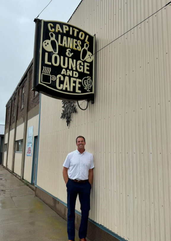Under a vintage sign for Capitol Lanes & Lounge, Bryon pauses with an easy smile—classic Main Street character and local hangout charm. | Source: Instagram/sdbryonnoem