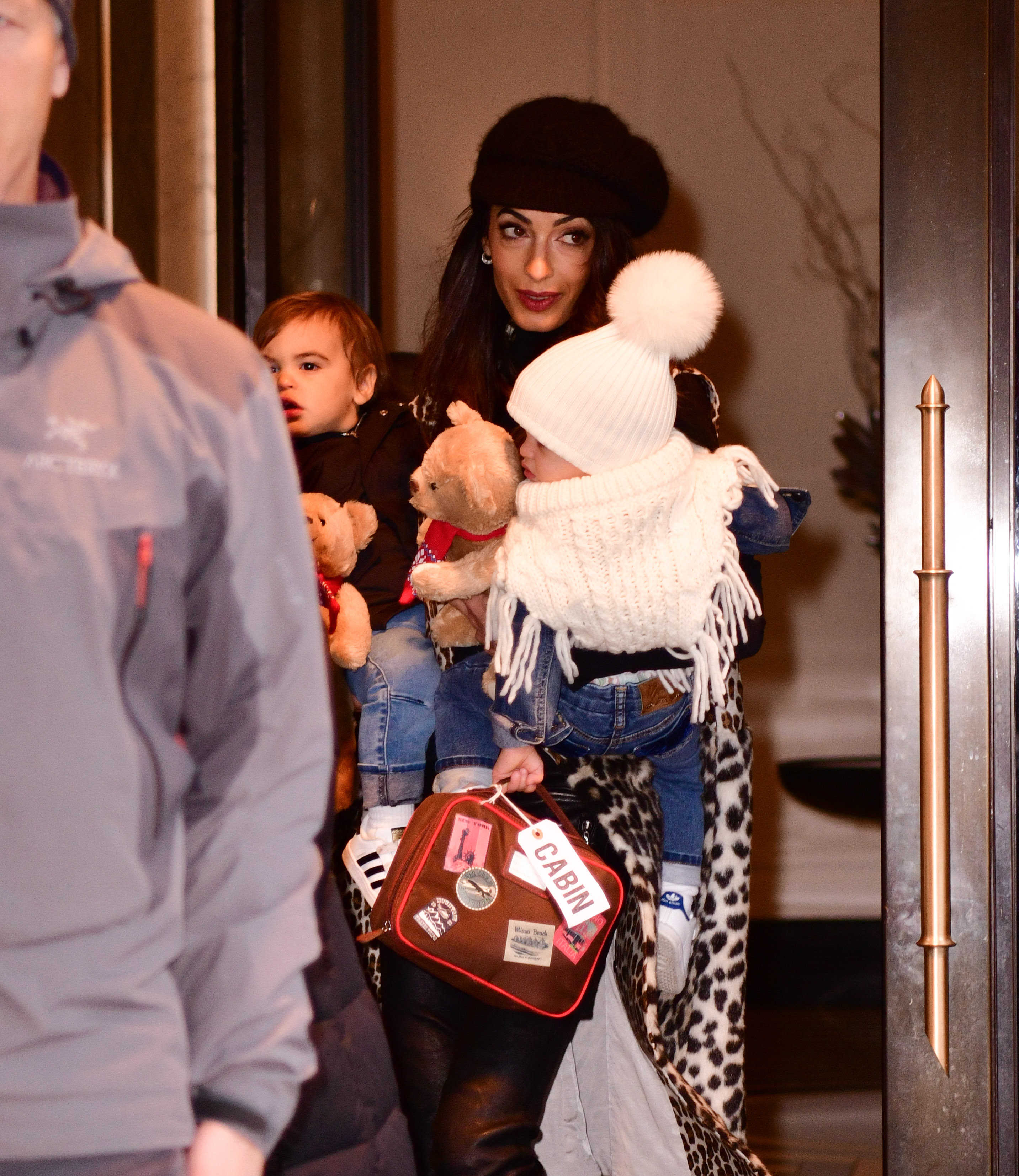 Amal Clooney is spotted in New York City on December 6, 2018, holding her children Alexander and Ella. Captured from a different angle, the photo highlights a rare moment of family life outside the public eye.