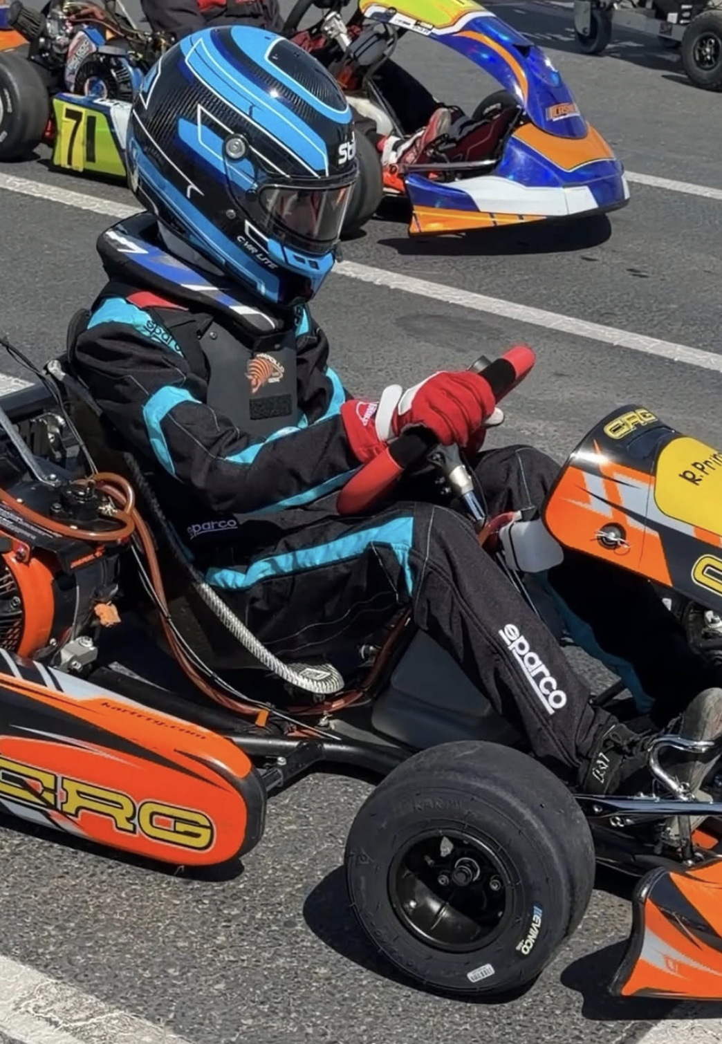 Rocky Prinze sat behind the wheel of his orange-and-black racing kart, wearing a blue helmet and Sparco racing suit. The teenager has been documenting his karting journey and sharing his progress toward his dream of becoming a Formula 1 driver on his own Instagram account. | Source: Instagram/@rockyprinze