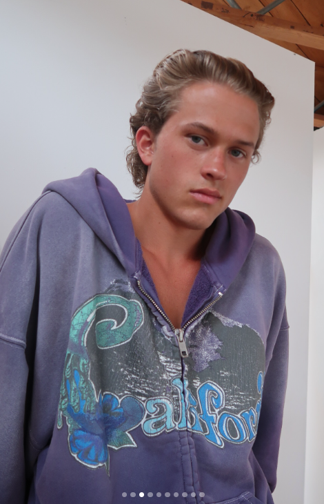 Deacon Phillippe poses in a purple graphic hoodie in one of the close-up images that prompted comparisons between him and his famous parents. | Source: Instagram/erl