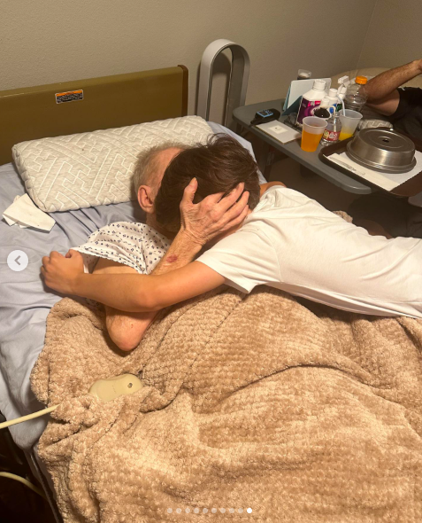 Carl Westcott and a loved one sharing a tender moment, as Westcott lays in a hospital bed. | Source: Instagram/kameronwestcott