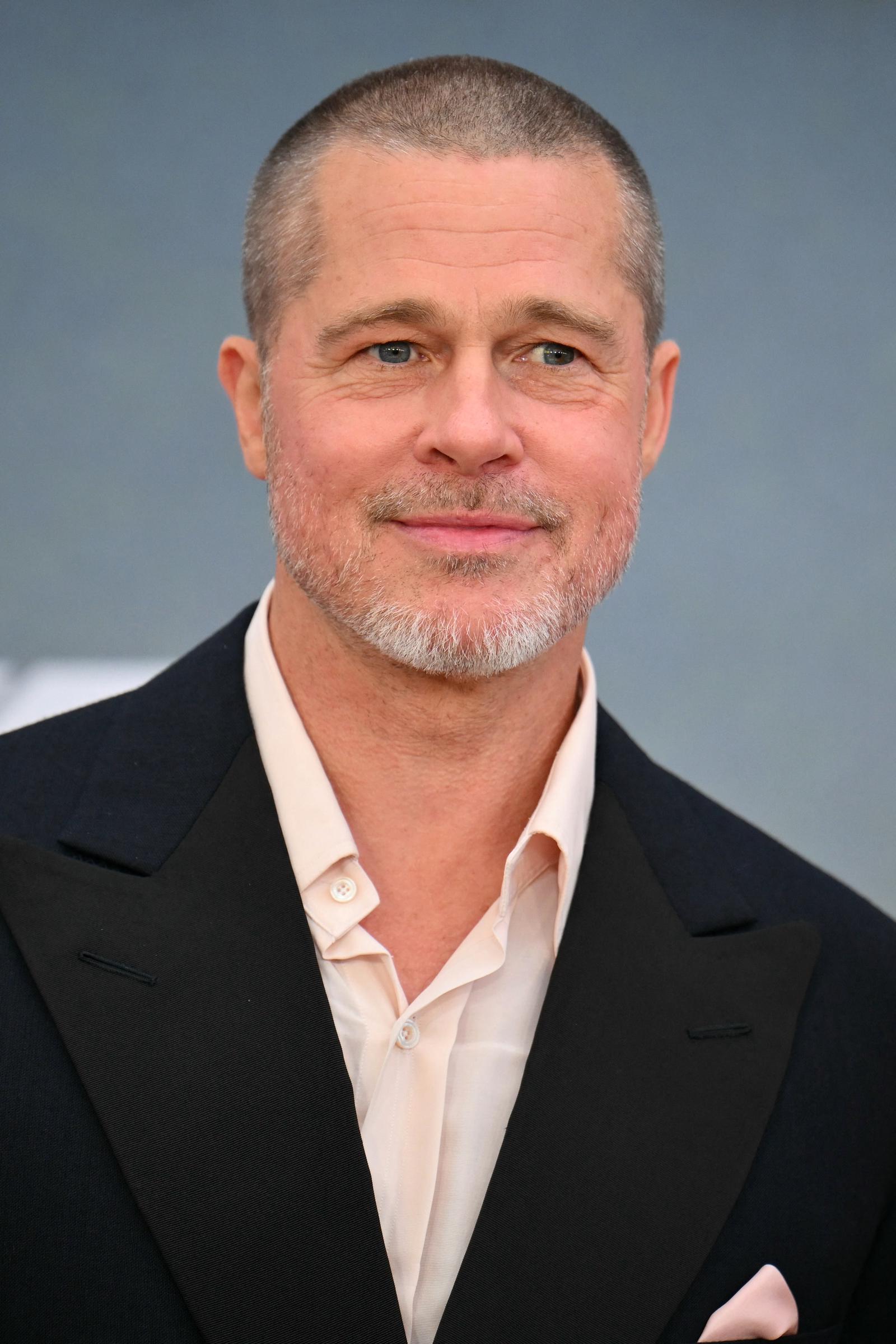 Brad Pitt debuts a closely shaved haircut and trimmed gray beard during the 2025 "F1" premiere in New York, pairing the updated look with a black suit and open-collar shirt.