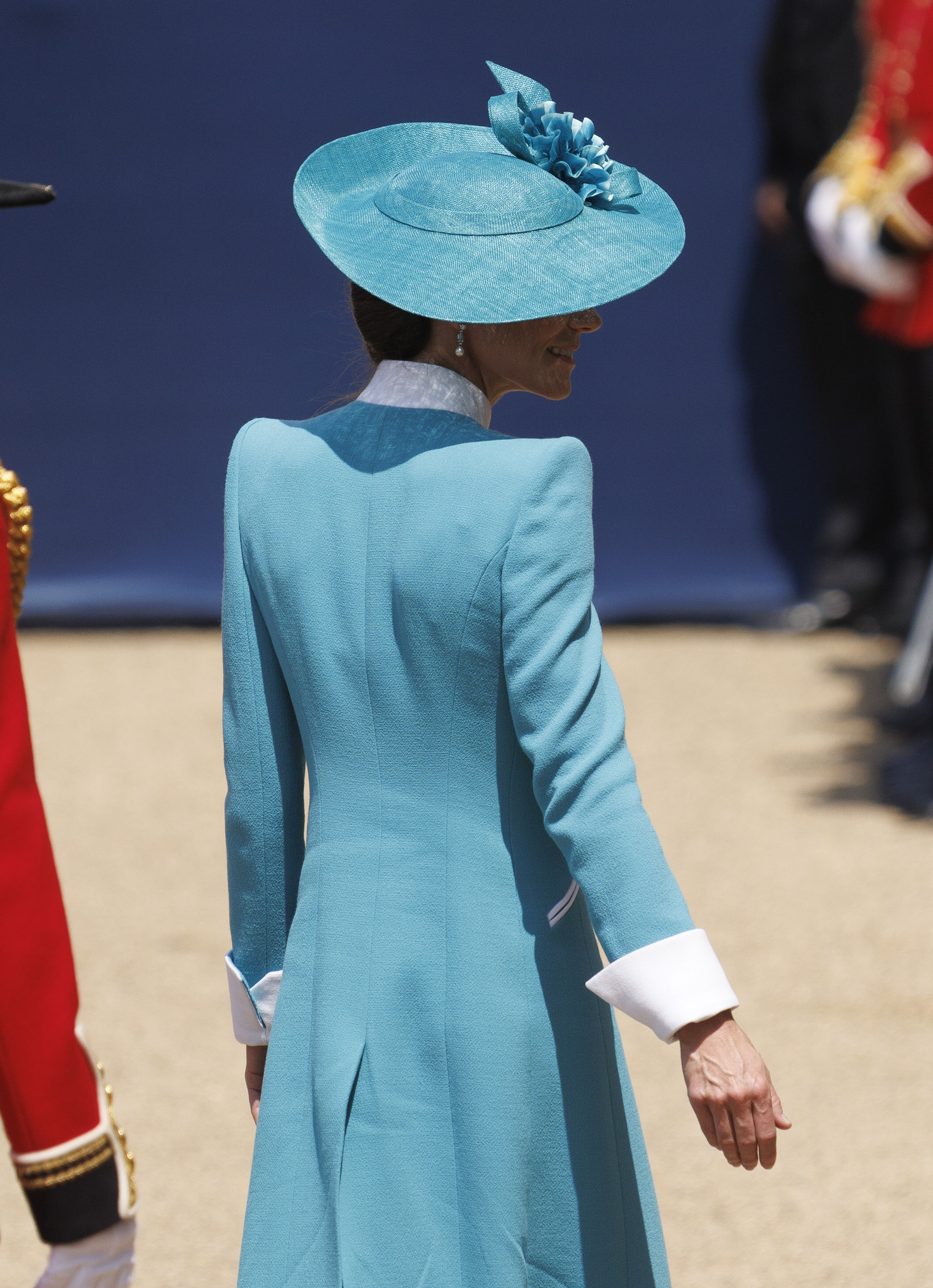 In a full-body back shot from the 2025 Trooping the Colour, Princess Catherine is seen in her striking teal coat with crisp white accents as she faces the ceremonial parade. Her matching hat and elegant updo complete the look, offering a graceful silhouette that reflects both tradition and modern royal style.