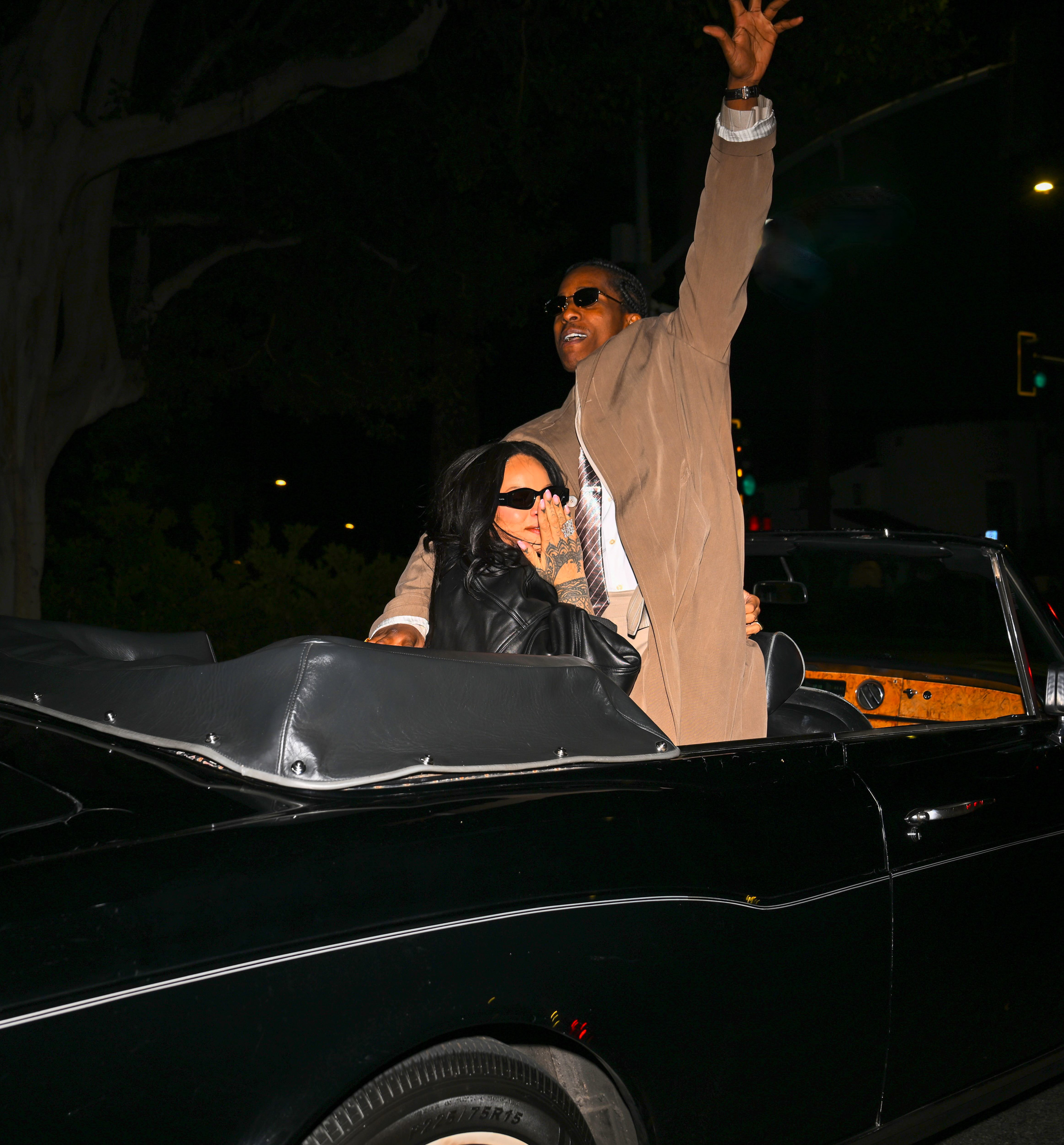 Rihanna looking on as A$AP Rocky gestures animatedly with his arm. | Source: Getty Images