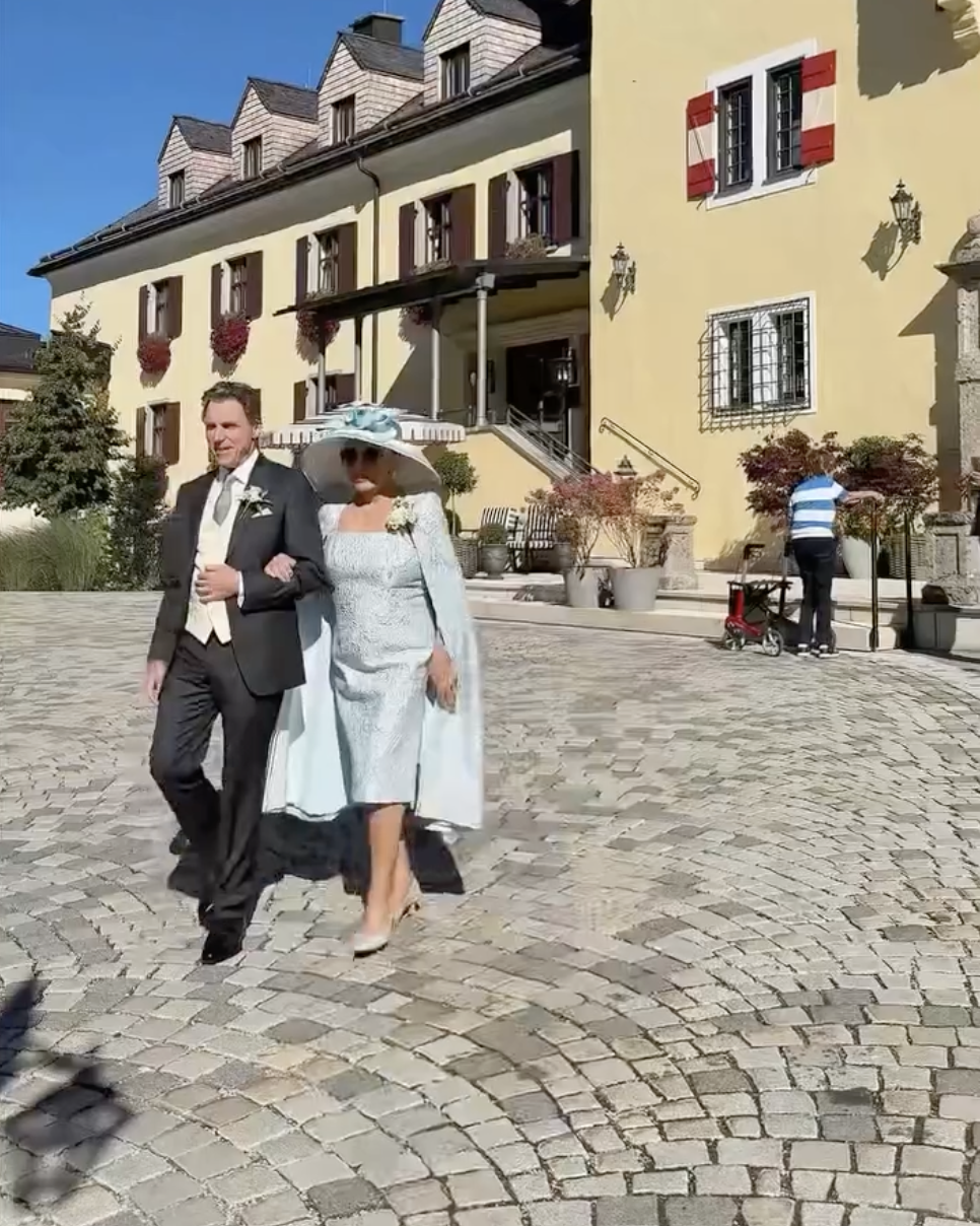 Joan Collins walks arm in arm with her son, Alexander Newley, as they make their way through the cobblestone courtyard, as posted on September 27, 2025 | Source: Instagram/sheelanewley