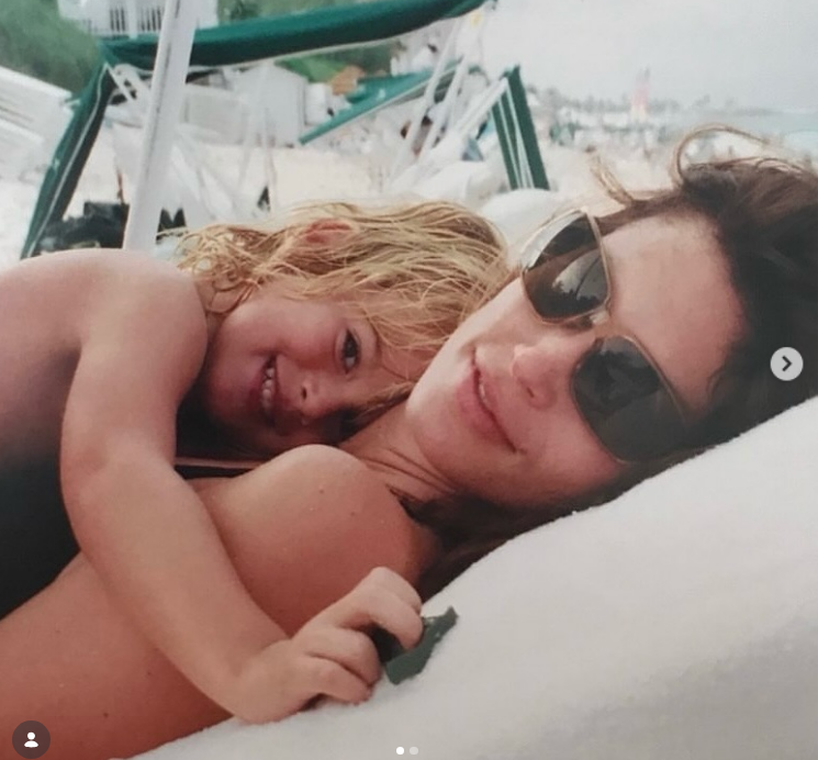 In a sweet throwback beach memory shared on July 2, 2026, for his birthday, supermodel Cindy Crawford lounges back in sunglasses while cuddling close with her young, blonde-haired son Presley Gerber as he hugs her from behind on a sandy lounge chair. | Source: Instagram/cindycrawford