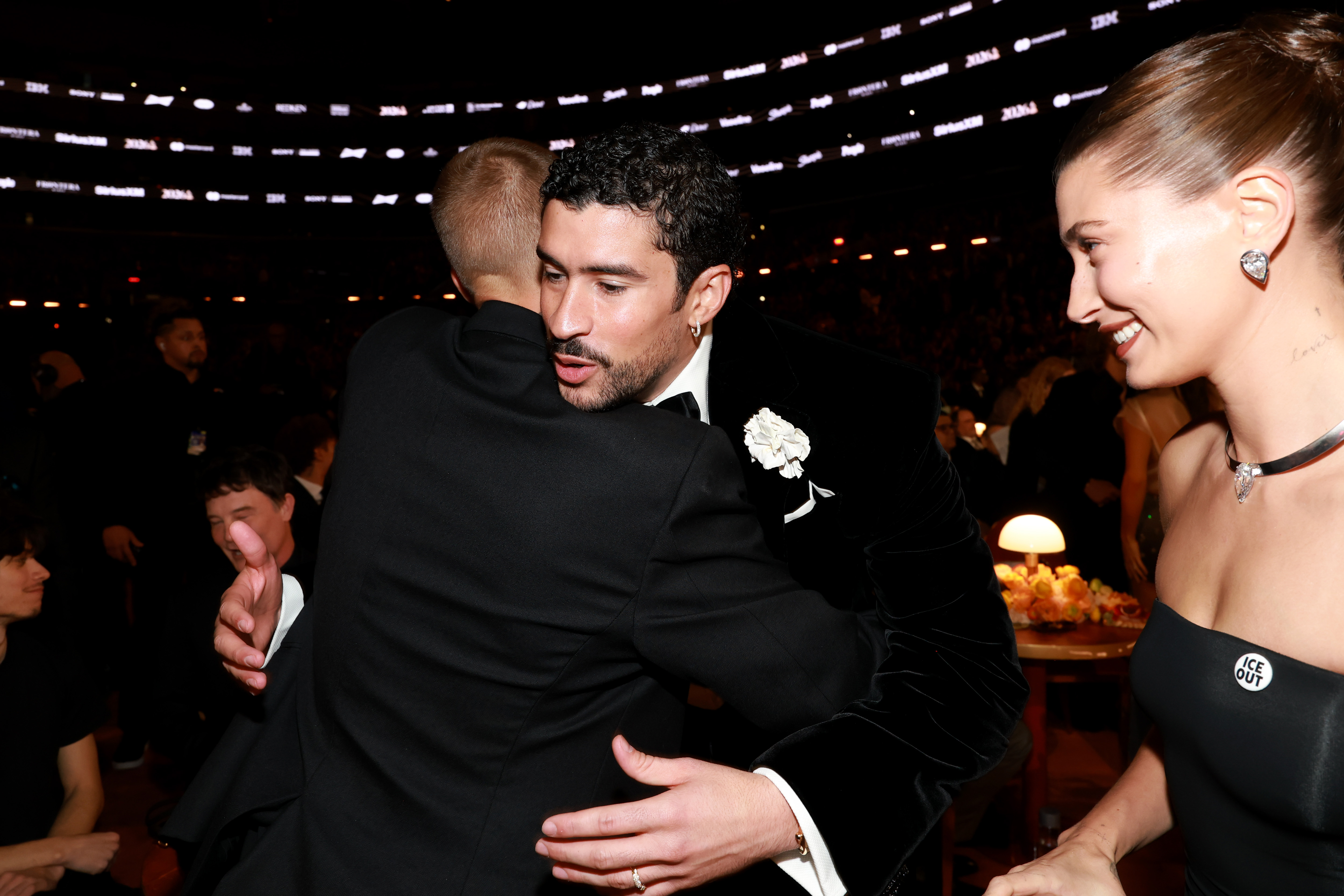 Justin Bieber is photographed with Bad Bunny as Hailey Bieber looks on.