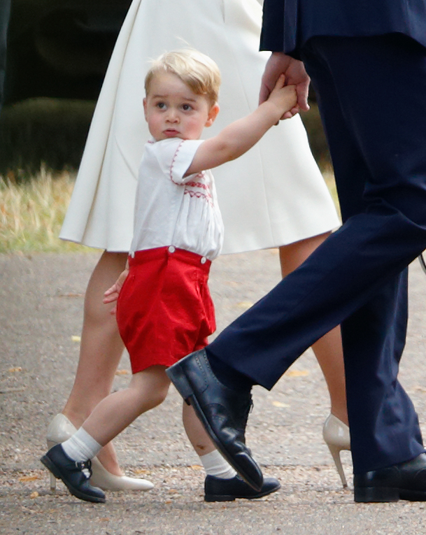 A young Prince George holds his father's hand at Princess Charlotte's christening in Norfolk on July 5, 2015. More than a decade later, George is adjusting to life away from his family as a boarding student at Eton College. | Source: Getty Images