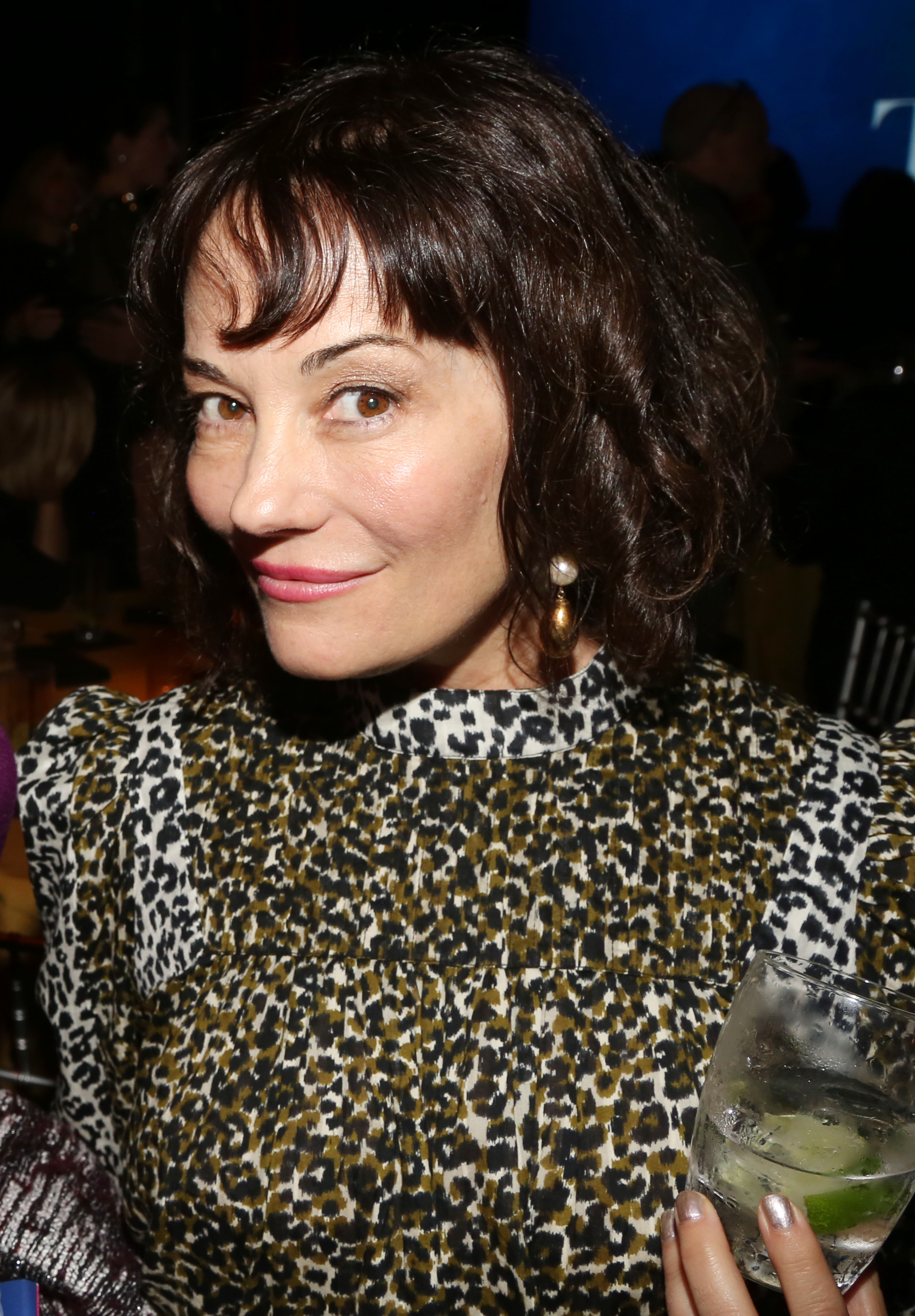 Natasha Gregson Wagner poses at the opening night after-party for the Broadway play "Left on Tenth" at The Edison Ballroom in New York City on October 23, 2024. She wears a high-neck leopard print dress and holds a cocktail in one hand, smiling slightly for the camera.