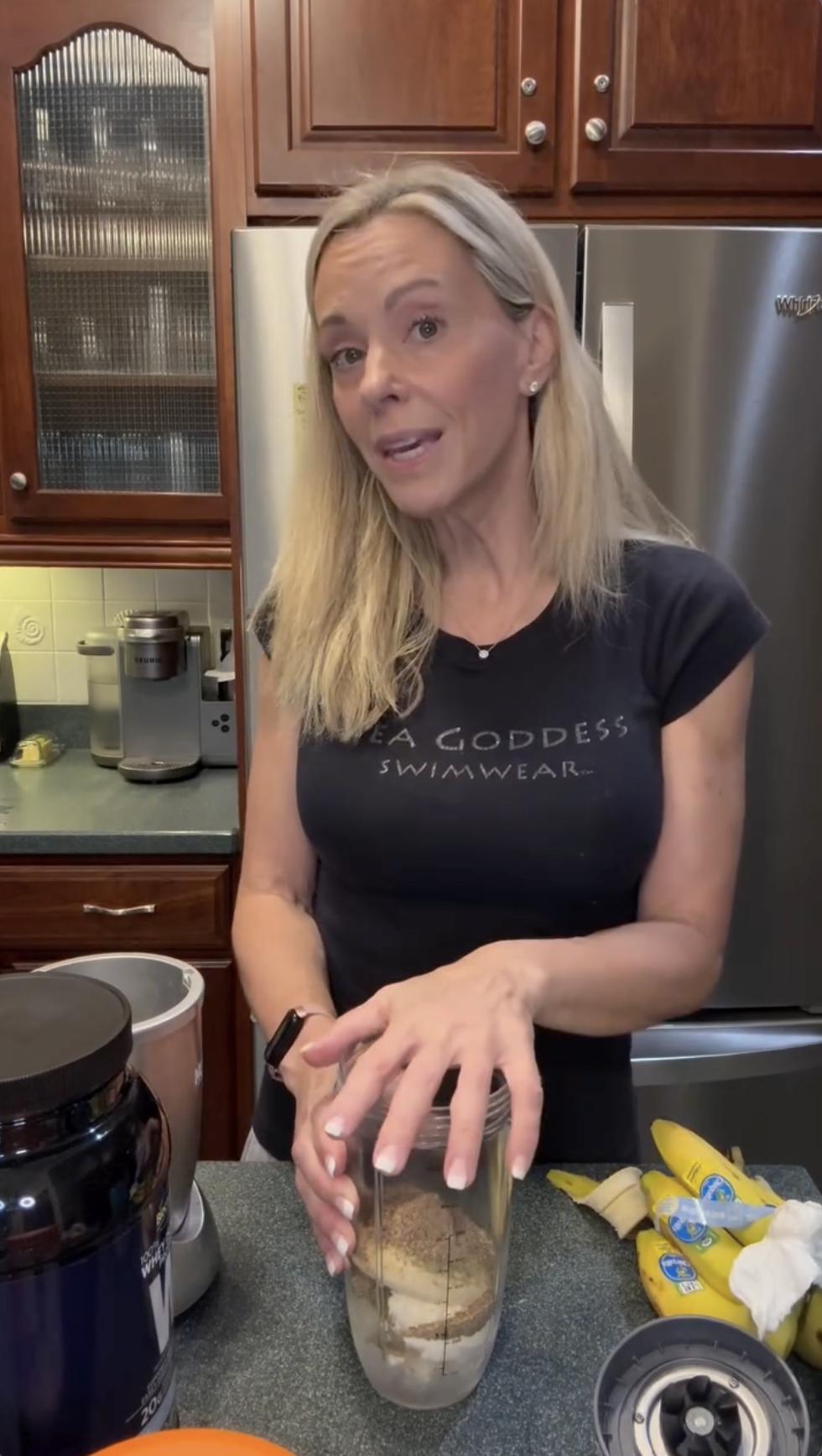 Kate Gosselin stands at the counter with bananas and protein powder nearby, resting her hands on a blender cup filled with ingredients. She explains her process, adding a personal touch to her kitchen video. | Source: Instagram/kateplusmy8