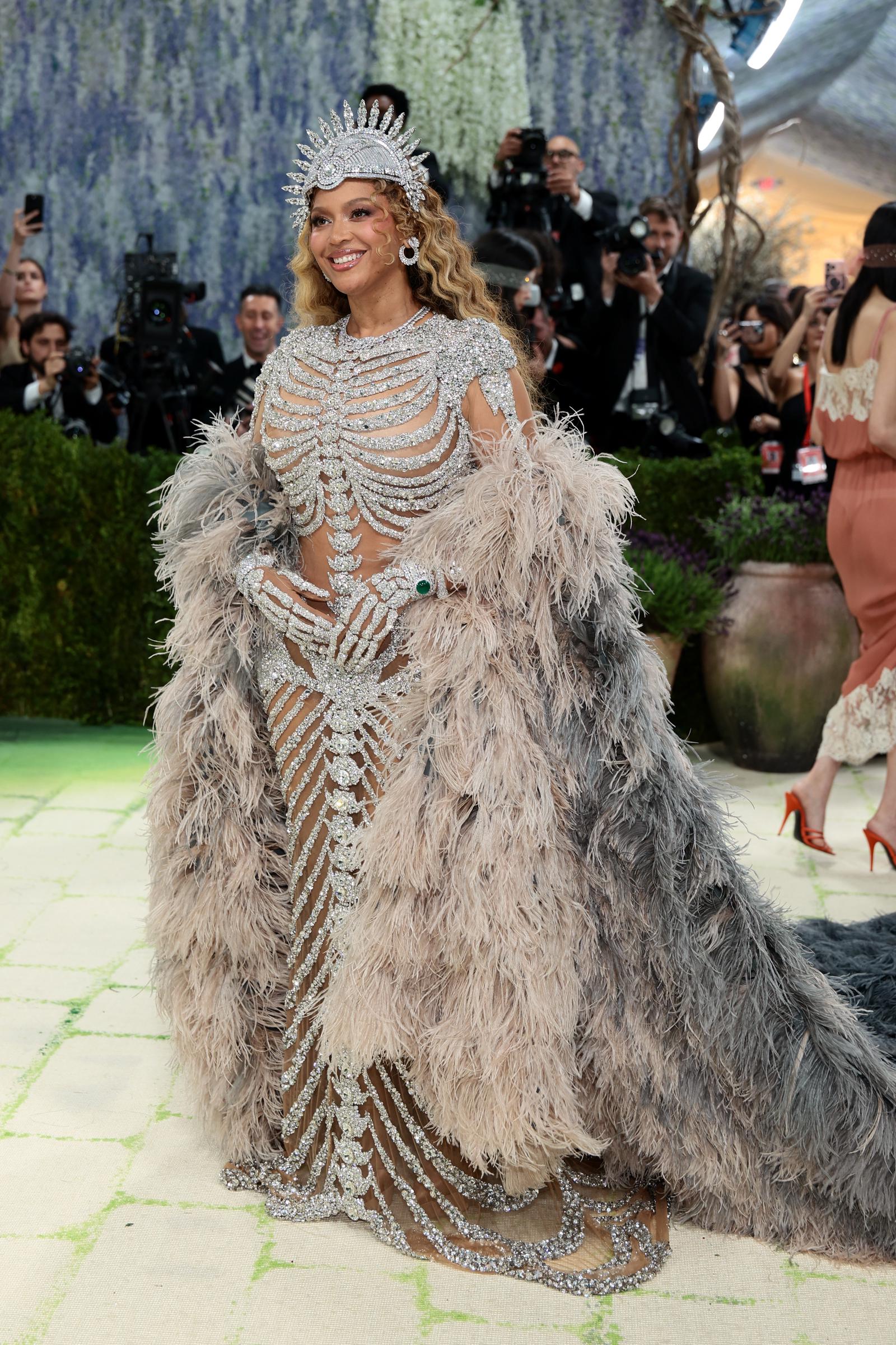 Beyoncé poses in her silver crystal gown and oversized feathered coat at the 2026 Met Gala | Source: Getty Images
