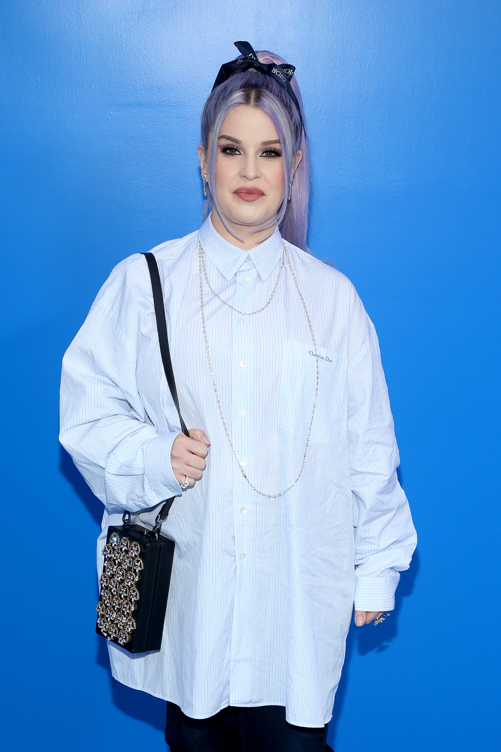 Kelly Osbourne attends the Dior Men's Spring/Summer collection event in Los Angeles in 2022, showcasing lavender hair and an oversized designer shirt ensemble. | Source: Getty Images