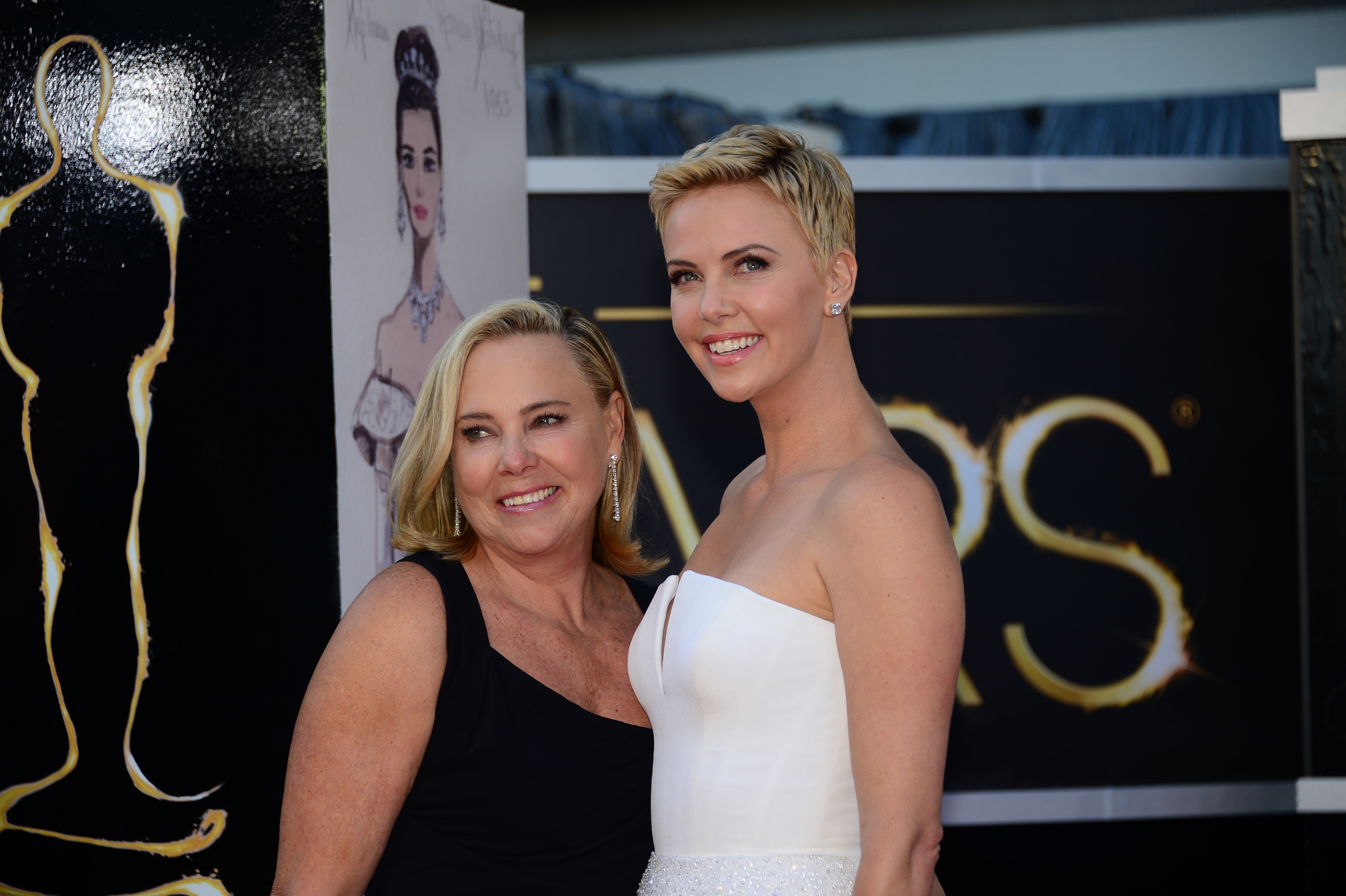 Charlize Theron(R) and her mother arrive on the red carpet for the 85th Annual Academy Awards in Hollywood, California on February 24, 2013. | Source: Getty Images