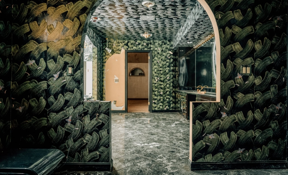 In a Facebook post dated April 7, 2026, photographer Johnny Joo showed one of the striking interiors of Mike Tyson's former Ohio mansion. Dark patterned walls and ceilings surround an arched opening leading toward a marble-floored bathroom, offering a glimpse of the elaborate decorative choices that remained inside the property long after the boxer had moved away. | Source: Facebook/Johnny Joo