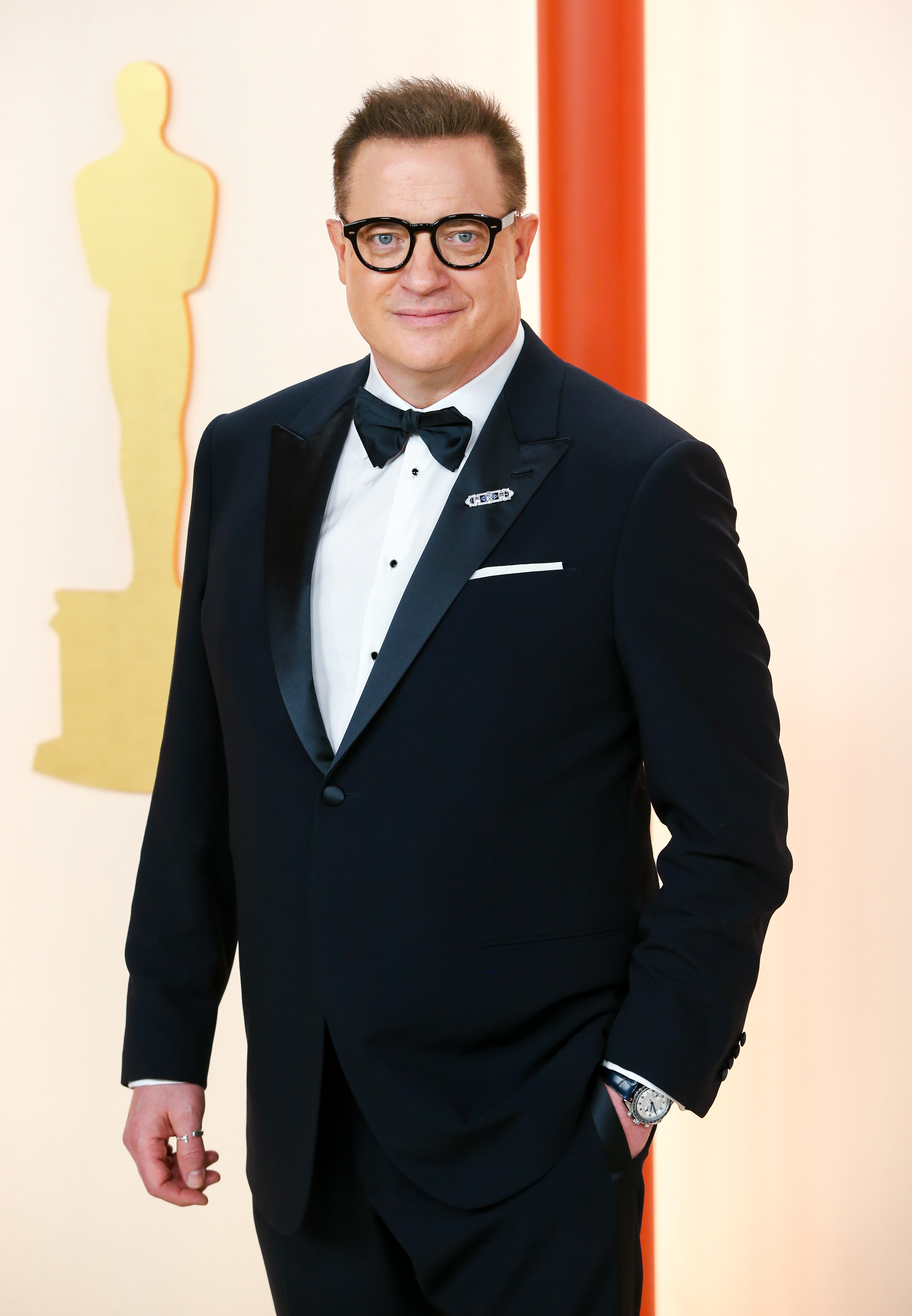 Brendan Fraser at the 2023 Oscars, where he wore a custom Giorgio Armani tuxedo and a vintage Cartier watch, completing his red-carpet look with his signature black-framed glasses. | Source: Getty Images