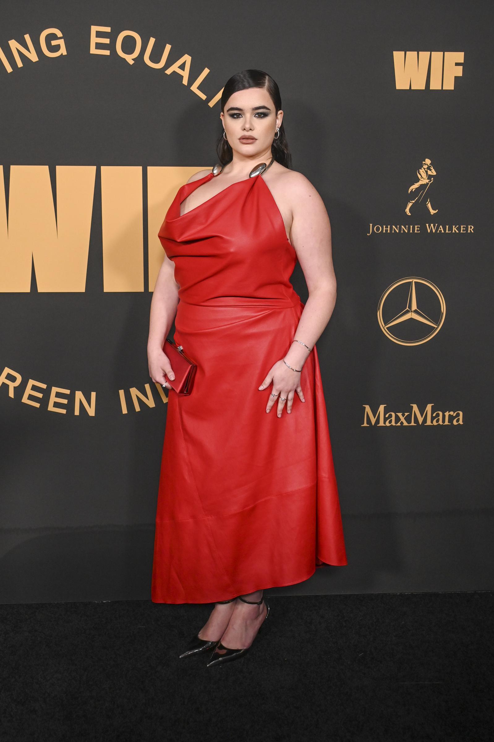 Ferreira is seen attending the 16th Annual WIF Oscar Party at NeueHouse Hollywood in Los Angeles, California, on March 10, 2023. She wears a striking red halter-neck leather gown with metallic accents at the straps, paired with matching heels and a red clutch. Her hair is styled in a sleek side part, complemented by bold smoky eye makeup and nude lips.