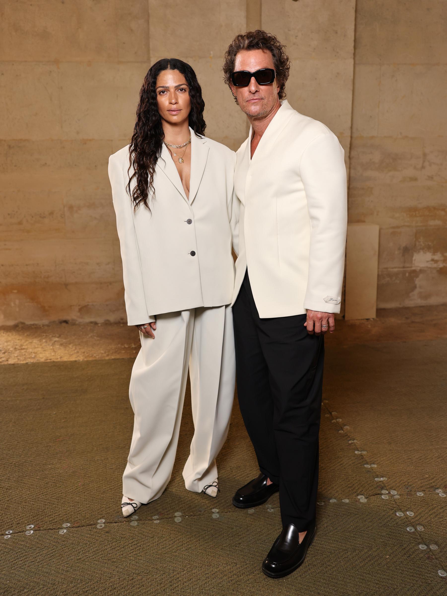 Alves complements McConaughey perfectly as the couple poses together. She looks stunning beside him in an oversized cream two-button blazer layered over matching wide-leg tailored trousers. Her look is finished with pointed cream pumps featuring black cap toes and delicate bow details. Alves's hair is styled in long, wet-look waves, adding a bold, fashion-forward touch to the elegant ensemble.