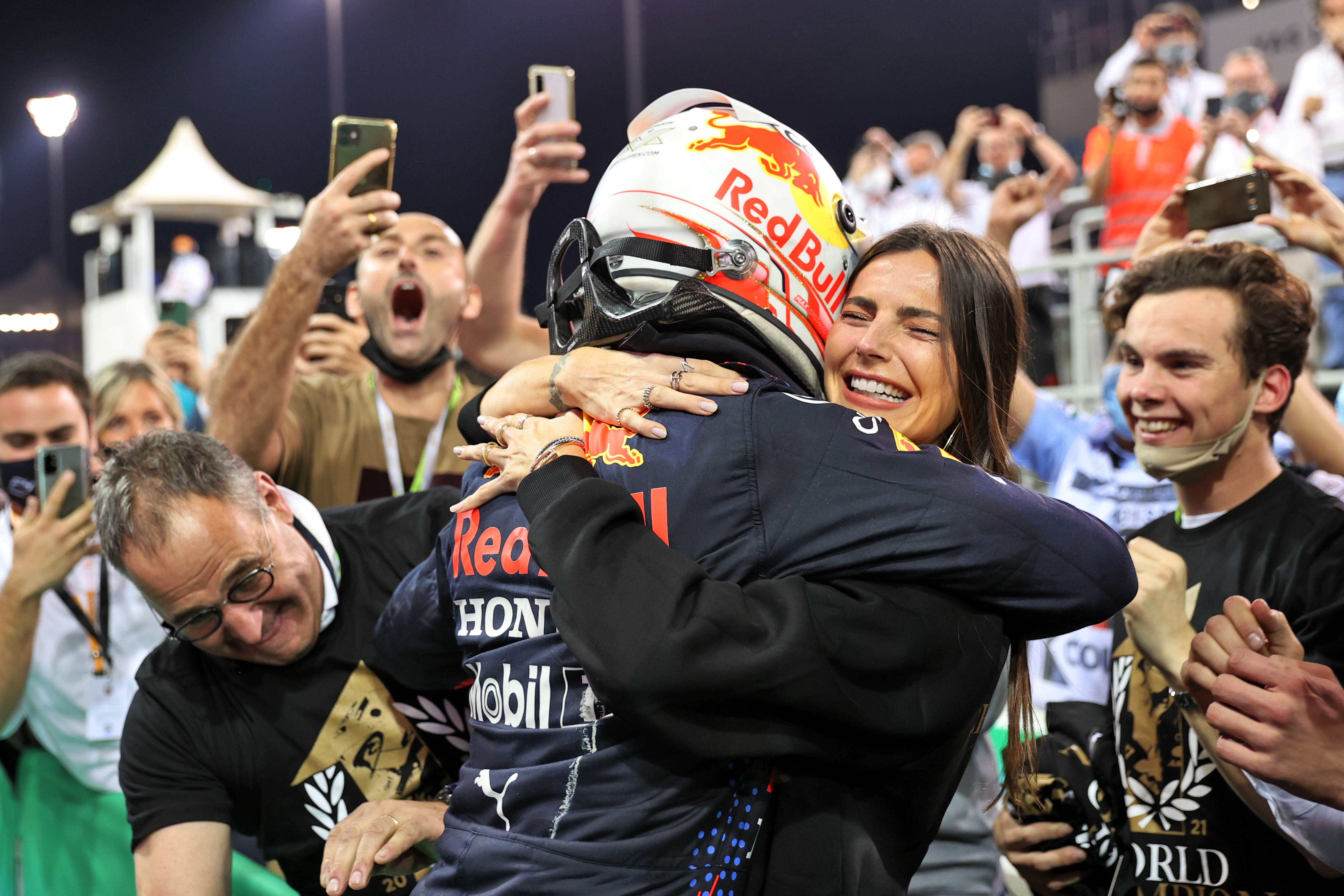Max Verstappen embraces and celebrates his first Formula One World Championship with his girlfriend Kelly Piquet after beating rival Lewis Hamilton to victory at the season-ending Abu Dhabi Grand Prix on December 12, 2021, marking a triumphant and emotional conclusion to the racing year.