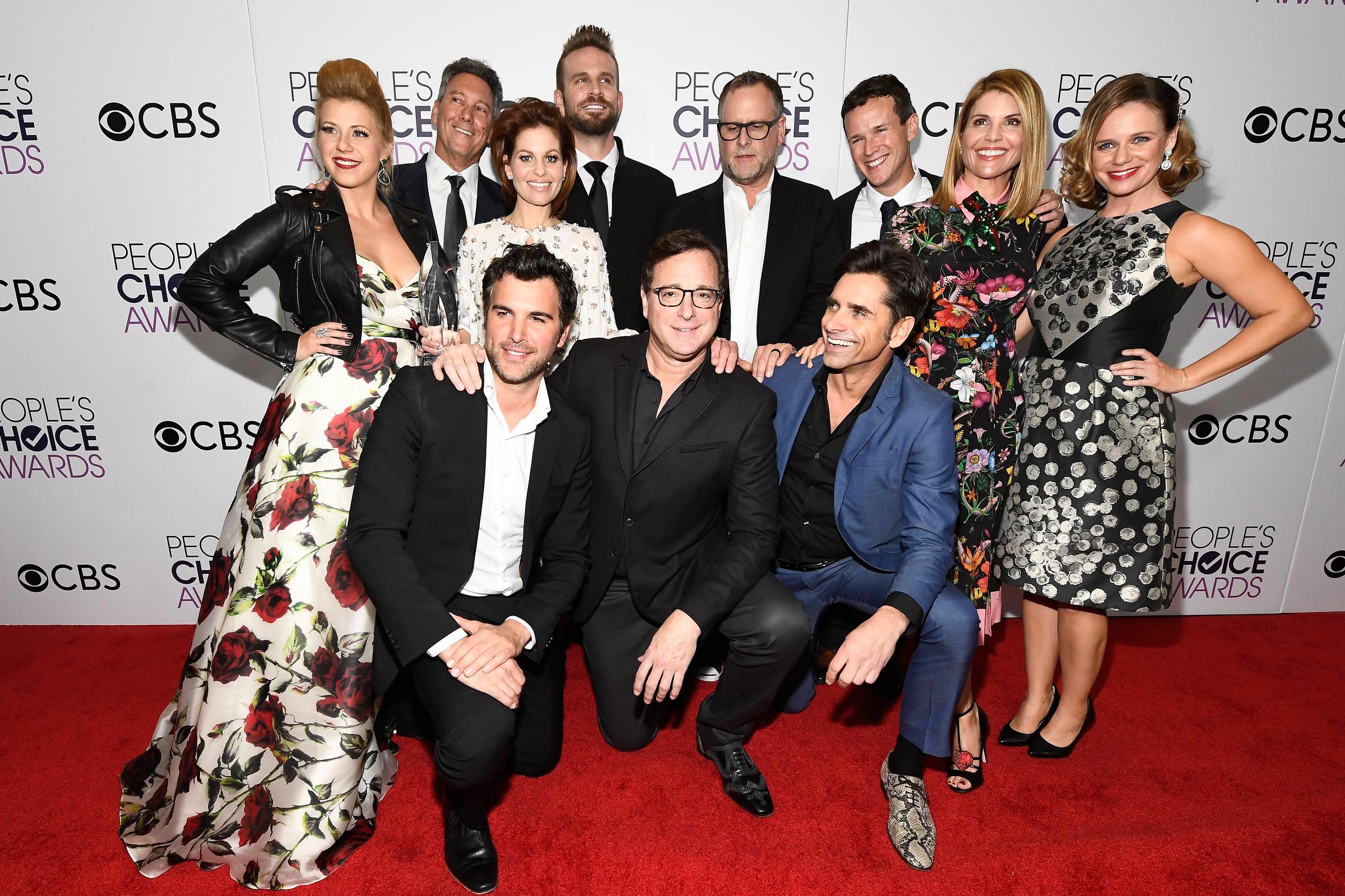 Jodie Sweetin, Candace Cameron Bure, Lori Loughlin, and John Stamos celebrate in the press room at the 43rd People's Choice Awards on January 18, 2017, alongside Bob Saget, Dave Coulier, and the cast of "Fuller House" after winning Favorite Premium Comedy Series. Decades after their childhood sitcom beginnings, the milestone honored the deep, enduring bond between the co-stars and highlighted how warmly audiences embraced their return to the screen.