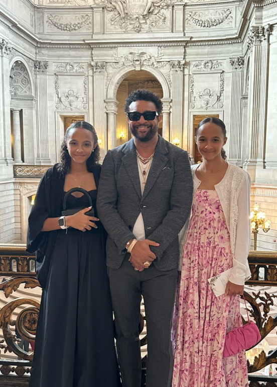 Shaggy stands between his twin daughters during a formal indoor visit | Source: Instagram/direalshaggy