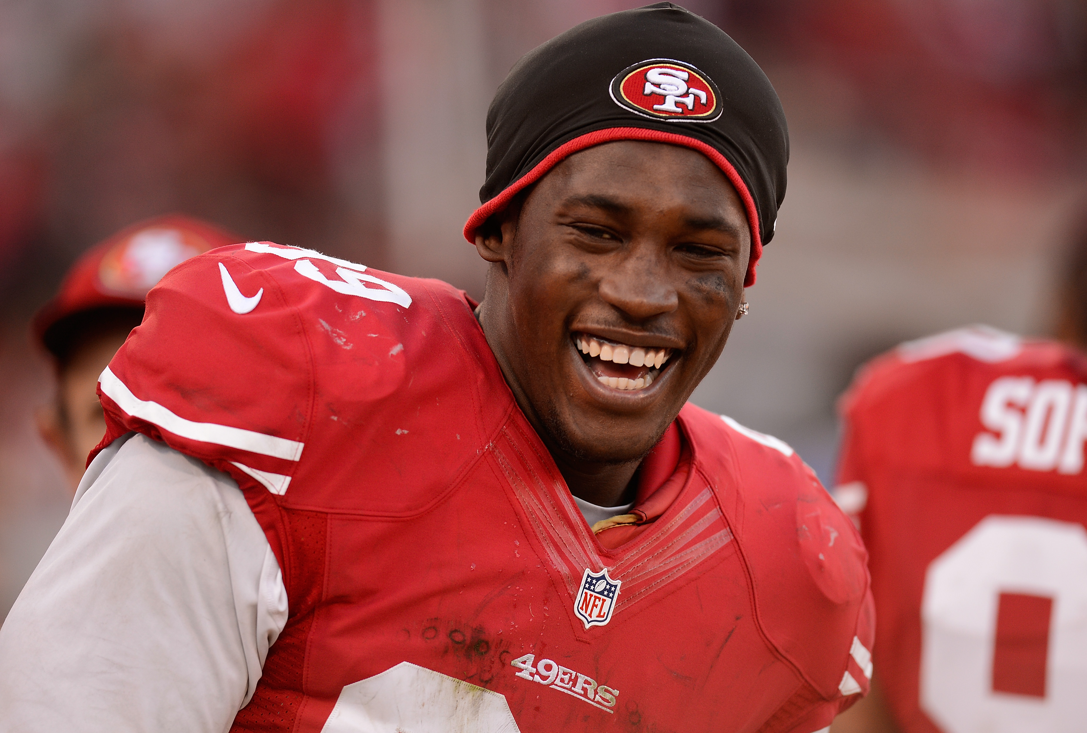 Aldon Smith #99 of the San Francisco 49ers smiles as he looks on from the sidelines at Candlestick Park on December 30, 2012 | Source: Getty Images